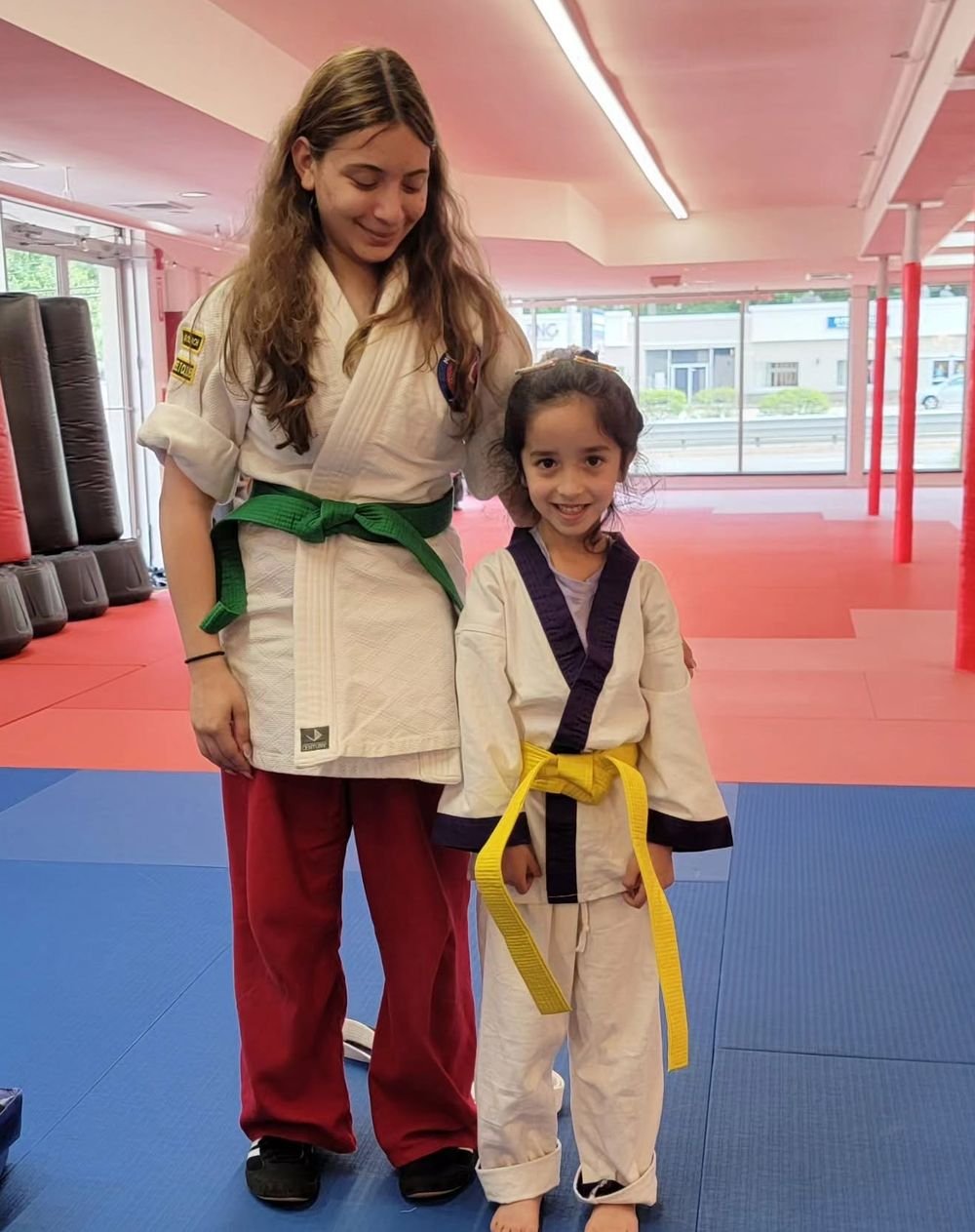 A Leadership Team student standing with a young Little Ninja at Metrowest Academy