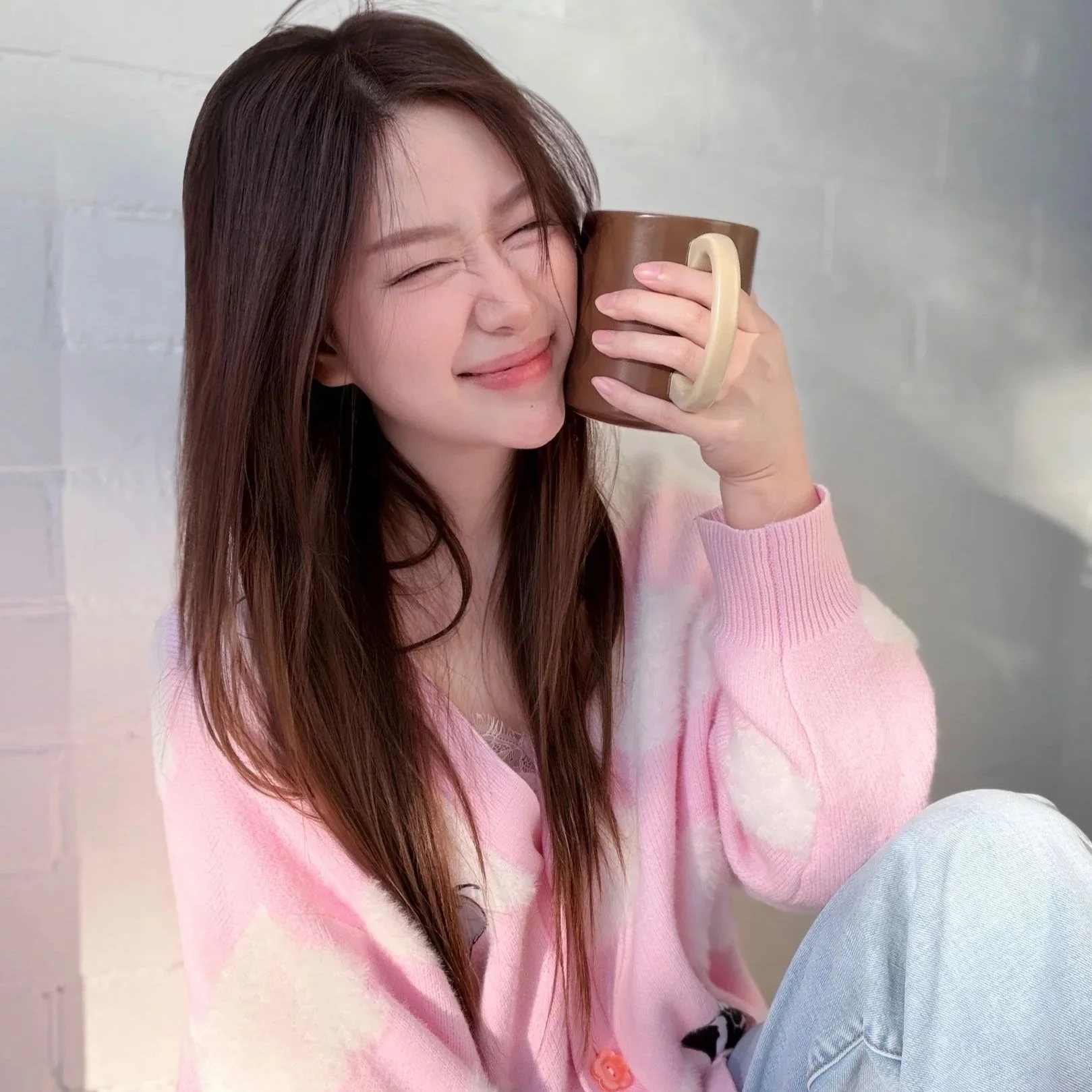 Isabella holding a cup to her face in a candid photo
