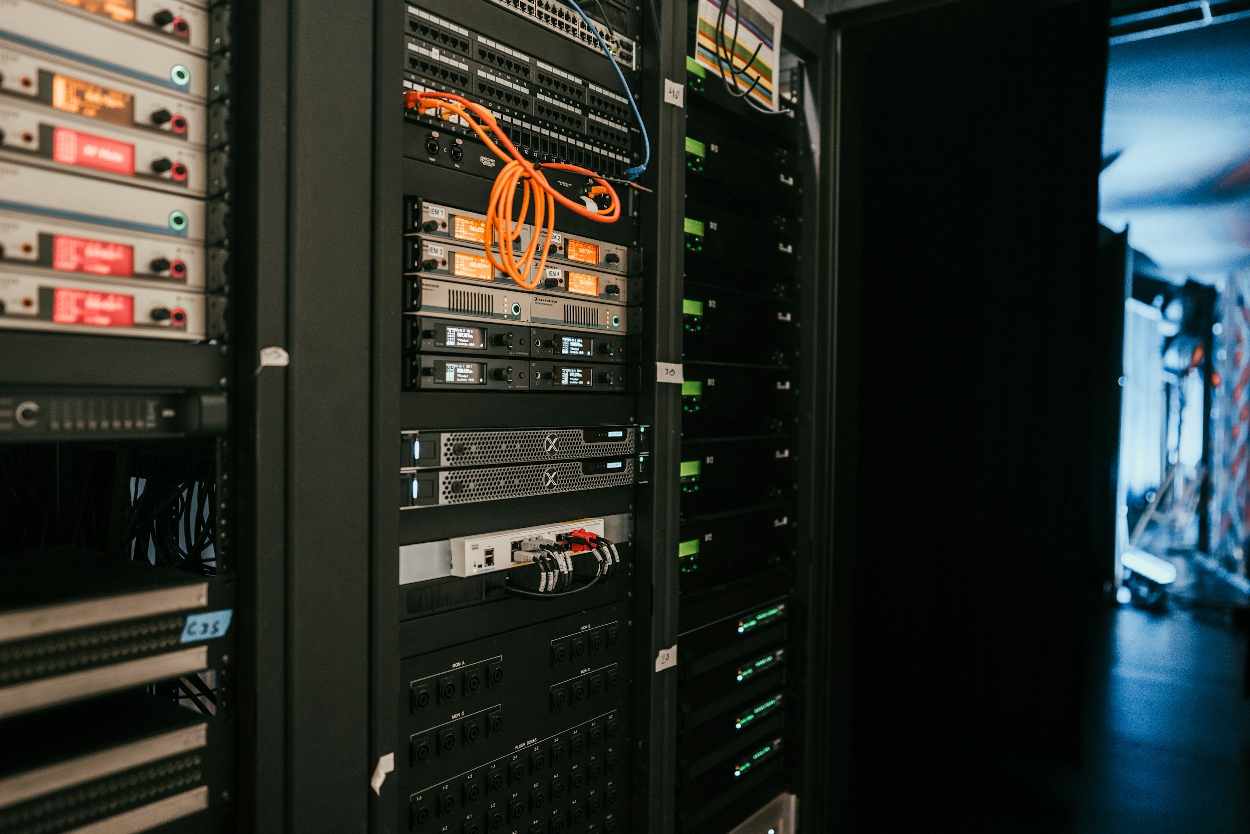 Serverraum mit mehreren Netzwerk-Racks und aktiven Glasfaser-Anschlusskabeln