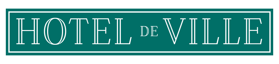 A sign that reads "HOTEL DE VILLE" in white letters on a green background.