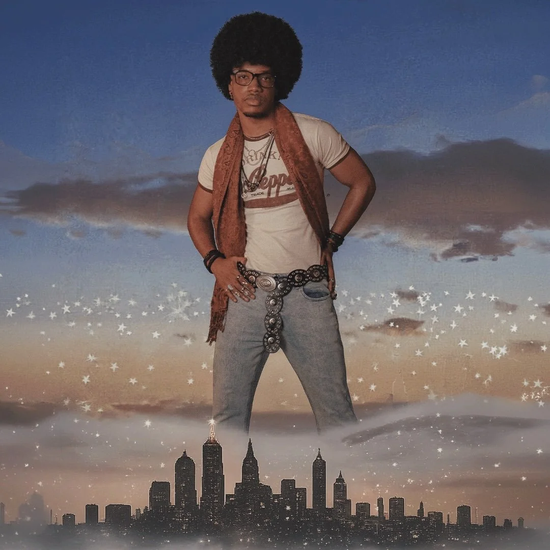 A man with an afro hairstyle, glasses, and casual clothing, standing in front of a surreal background of a city skyline and starry sky.