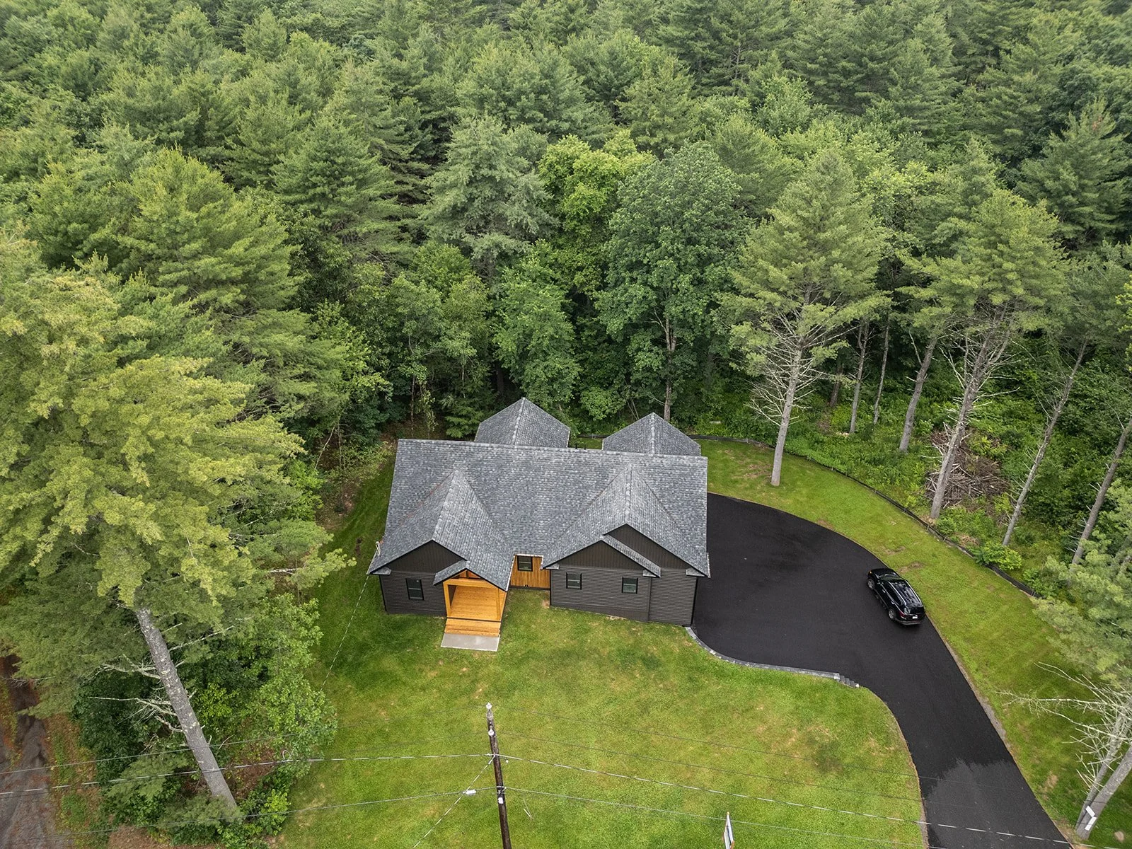 Aerial view of 20 Merrifield Road in Bernardston, MA, surrounded by mature woodland on a private 2.5-acre setting.