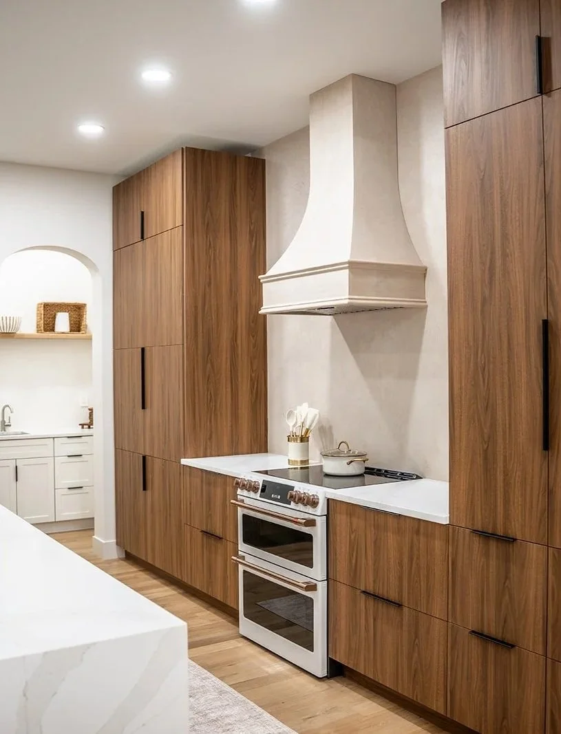 Custom kitchen at 20 Merrifield Road featuring warm wood cabinetry, quartz countertops, integrated appliances and a statement range hood.