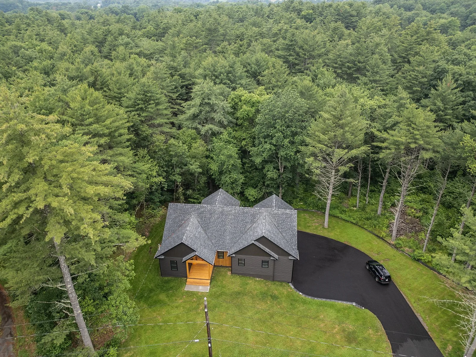Aerial view of 20 Merrifield Road in Bernardston, MA, surrounded by a private wooded setting on 2.5 acres.