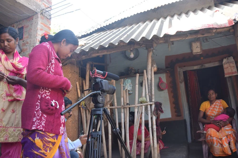Moumita Hansda (extreme right) and Behula Tudu (holding camera) capturing experinces of a tribal mother at Benagoria village of Manbazar.