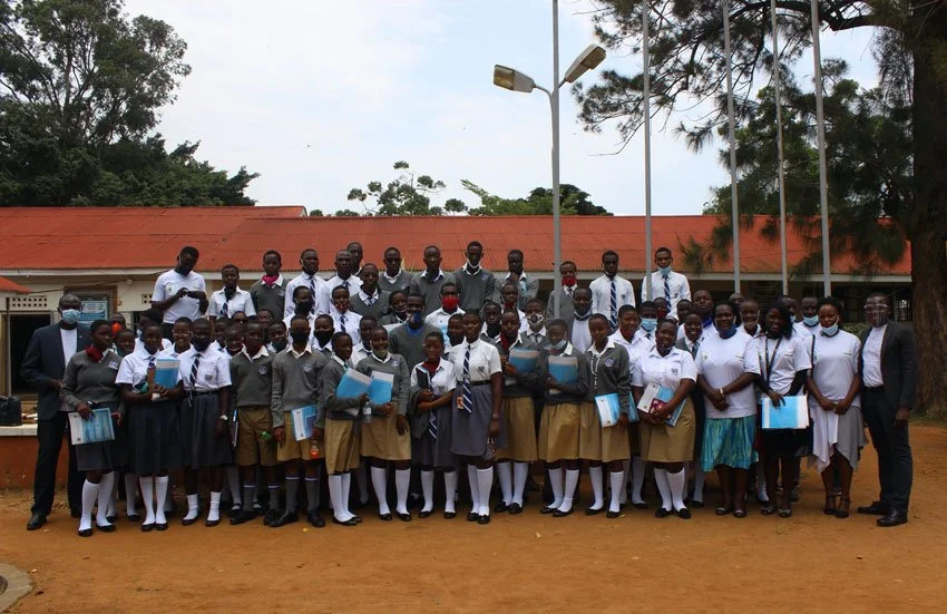 Students of Entebbe Secondary School and the trainers after the training. In blue are the training materials.