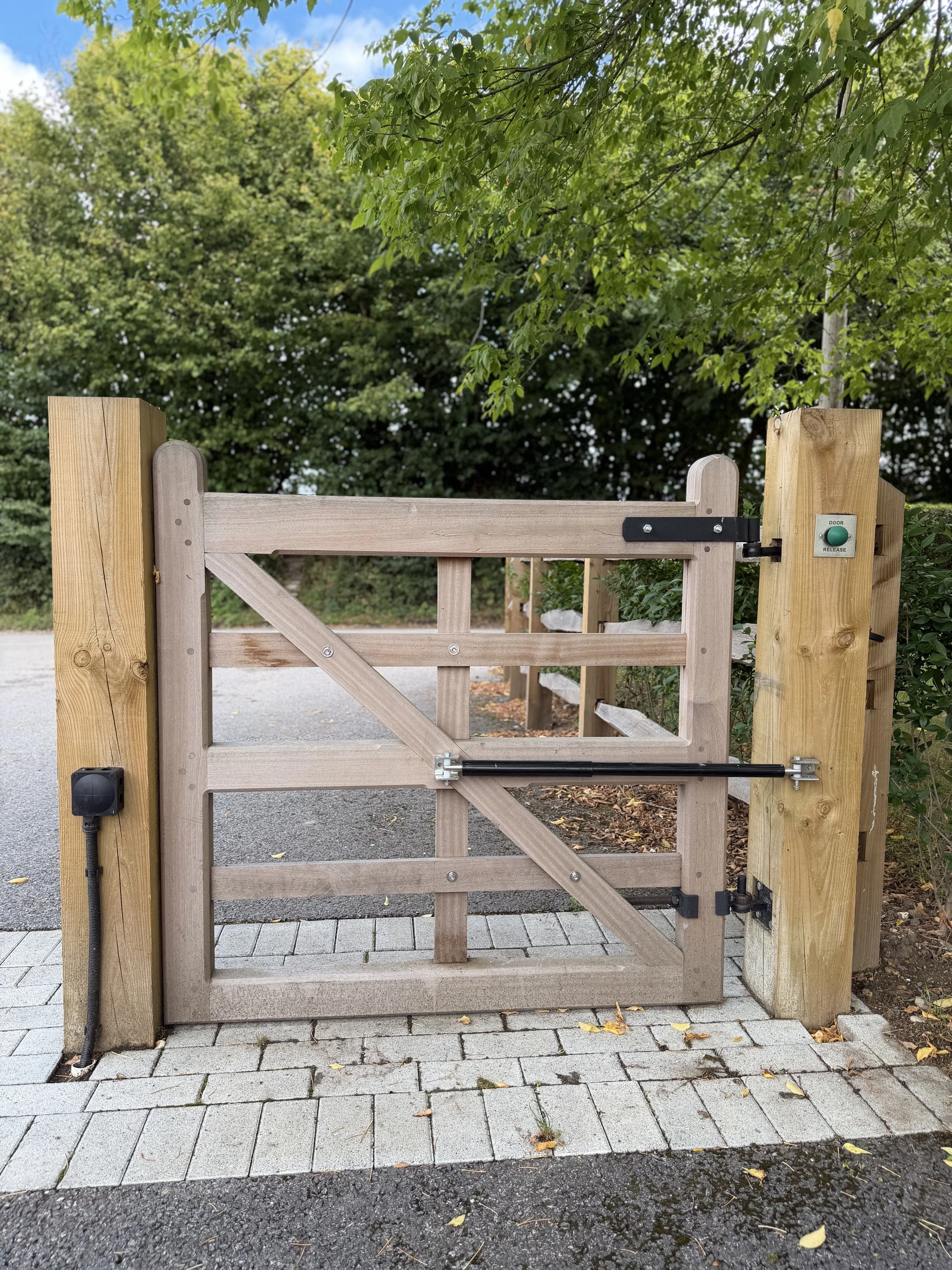 Timber pedestrian gate with an access control post beside it