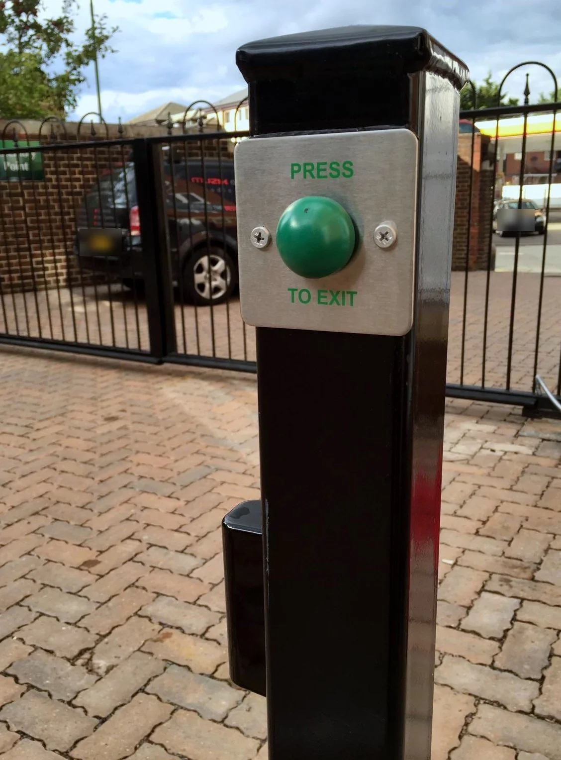 Press-to-exit button on a post beside the gate