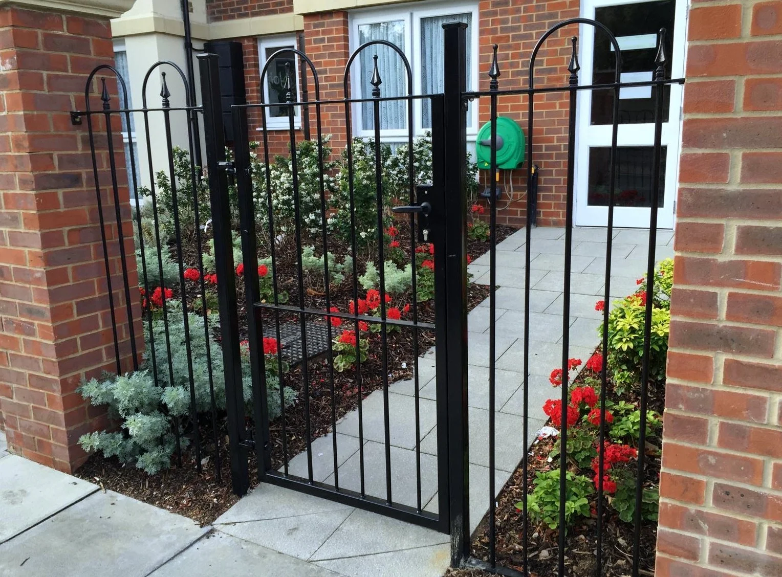 Bow-top pedestrian gate to a building entrance