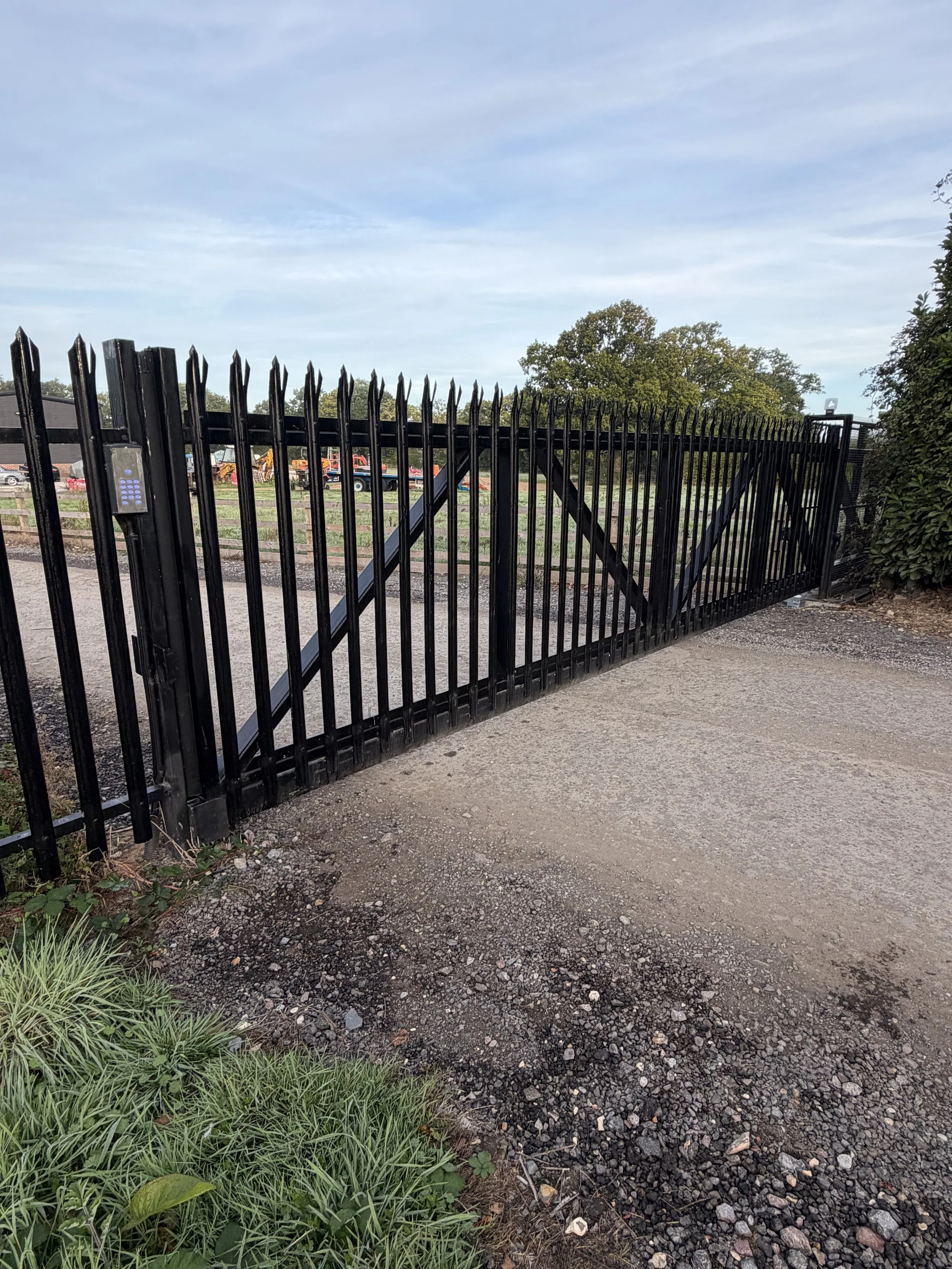 Black steel electric gate across a commercial site entrance