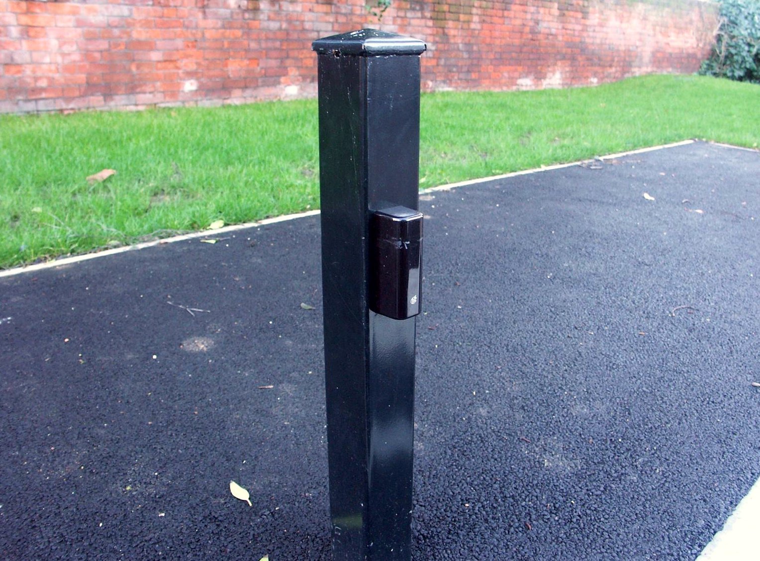 Gate control post beside a tarmac driveway
