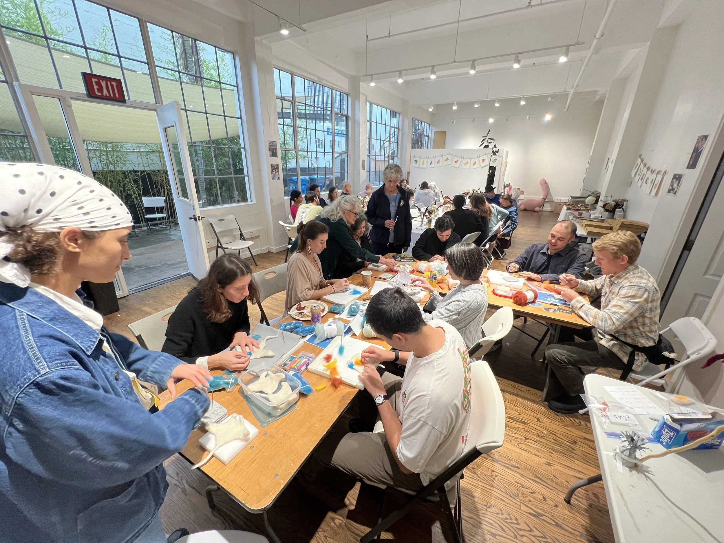 a crafting party with adults at a table working on dry felting