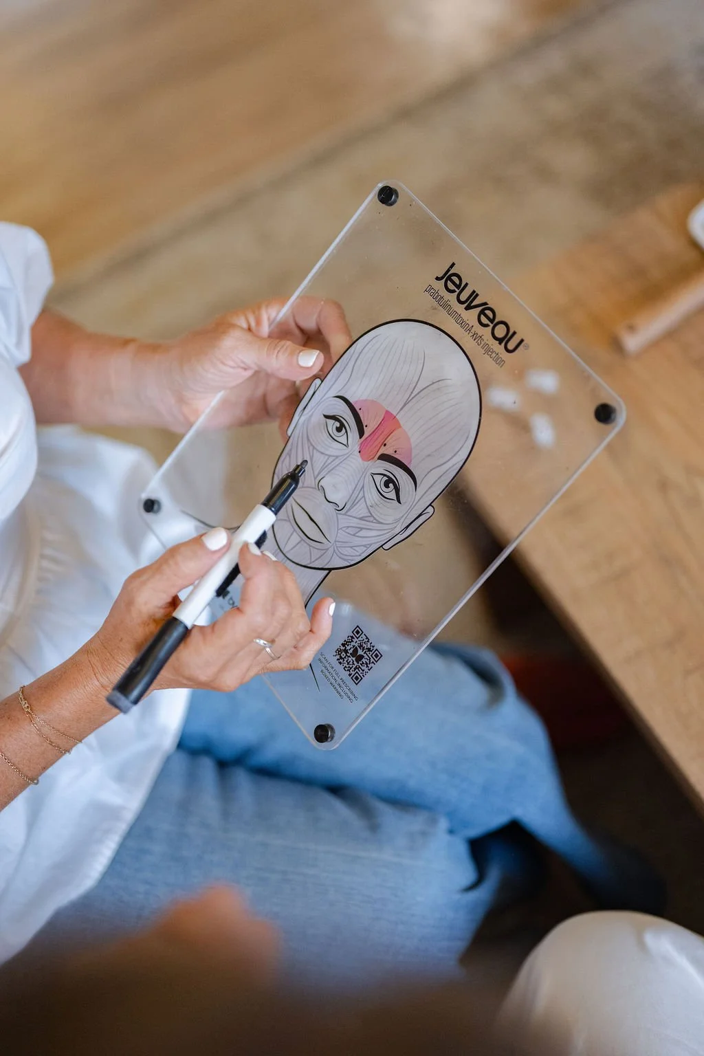 Nurse injector marking treatment points on a face diagram before a botox appointment in Wilmington, NC