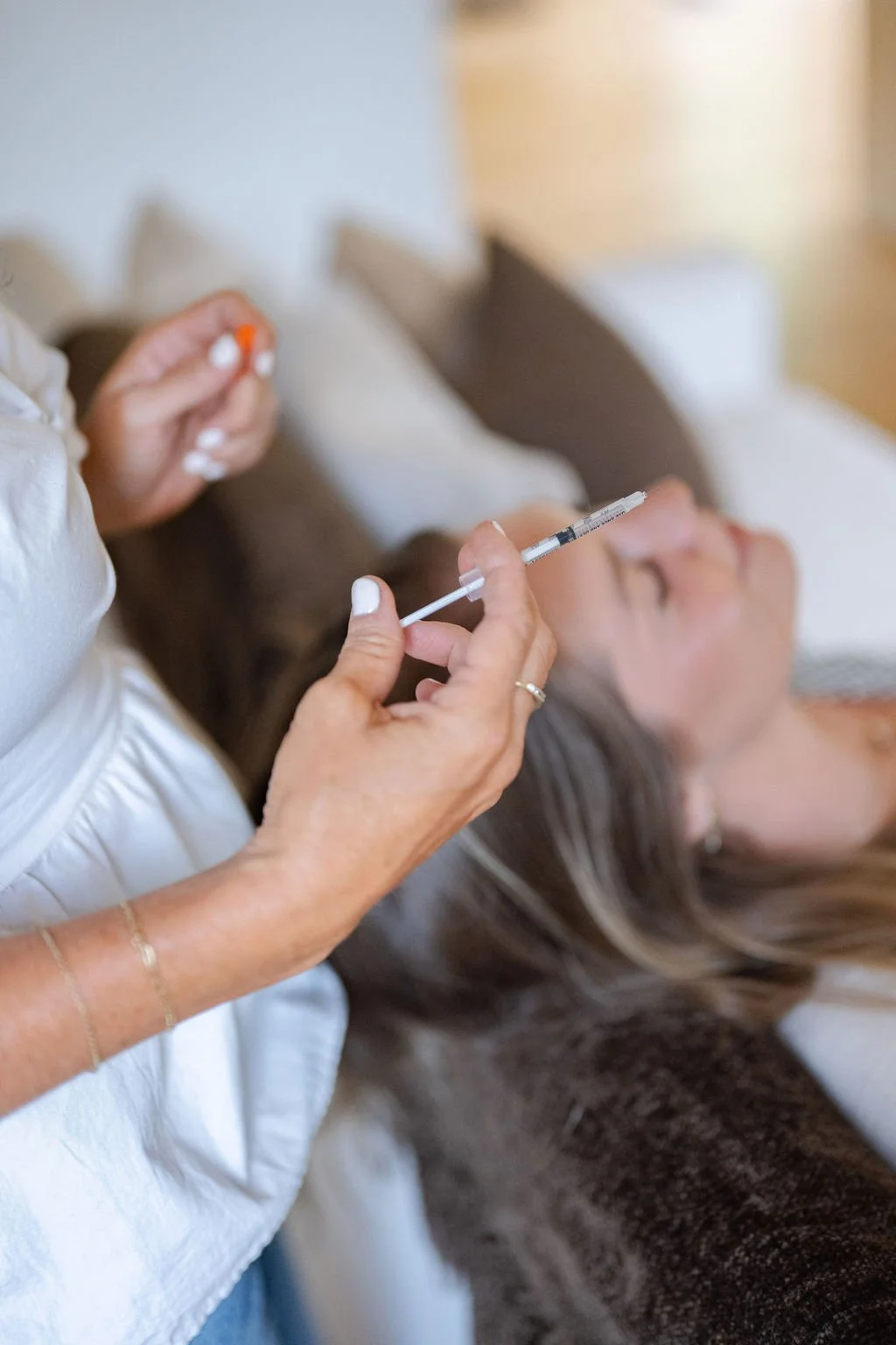 Nurse injector administering a botox treatment during an in-home appointment in Wilmington, NC