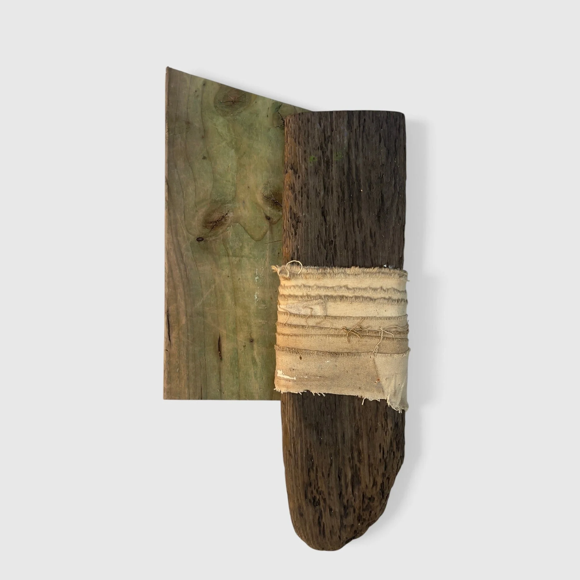 Working Object 01, 2026: Two overlapping pieces of weathered wood, with a strip of frayed canvas wrapped around one piece.
