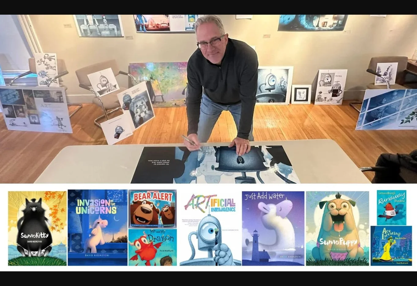 David Biedrzycki autographing artwork beside a display of his picture books.