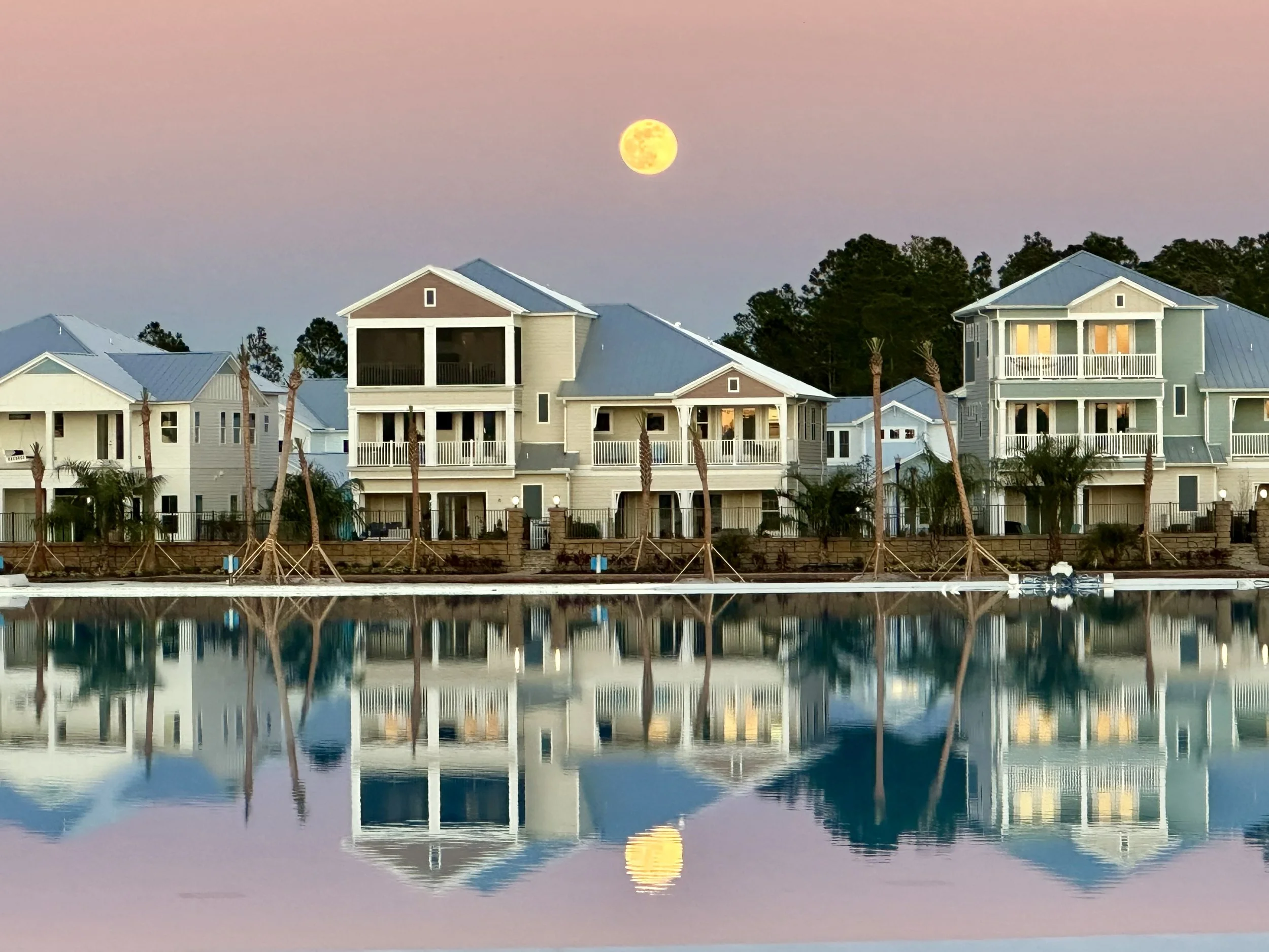 Moonrise over Beachwalk Crystal Lagoon with waterfront homes reflected in the water