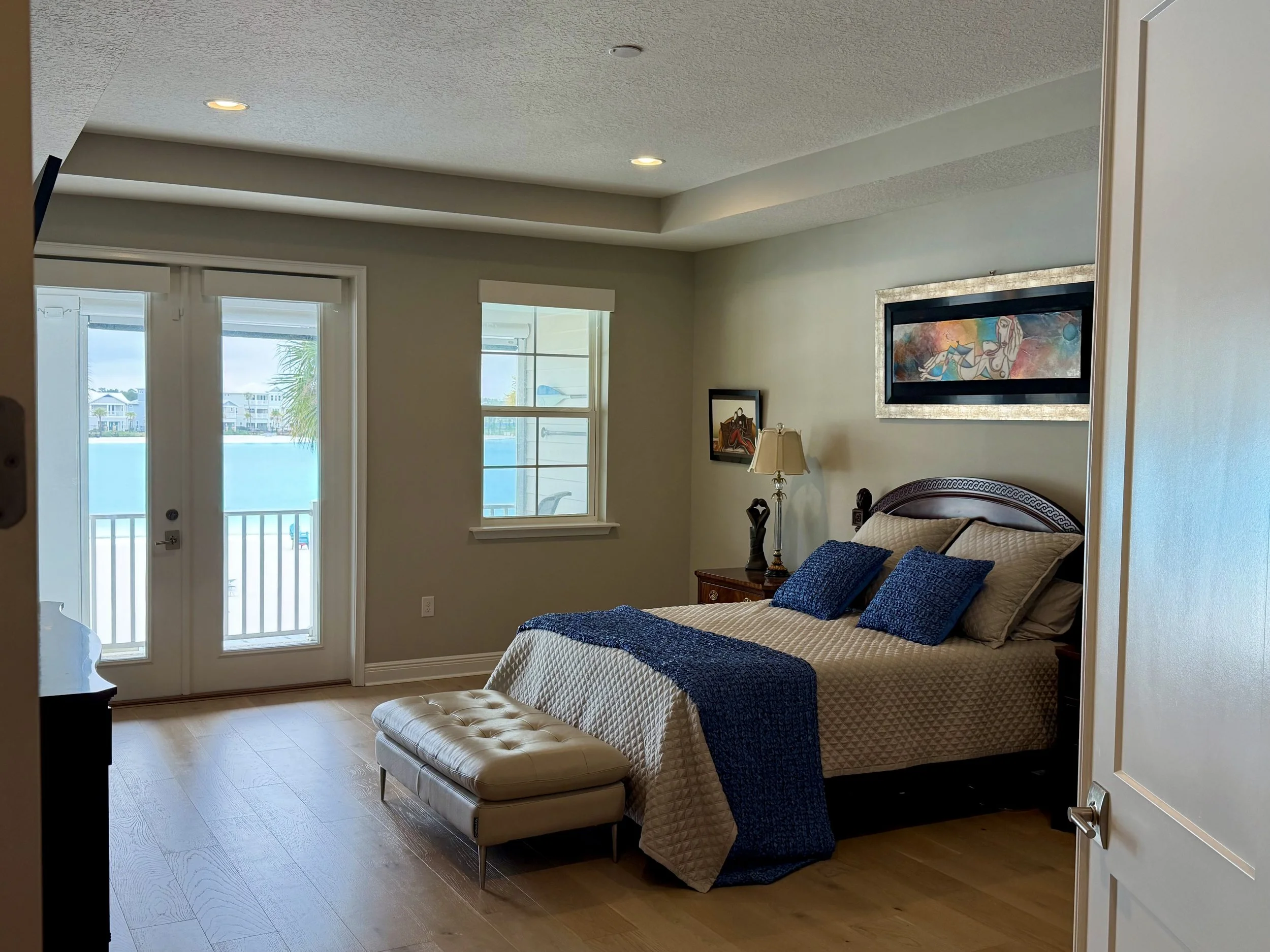 Primary bedroom with tray ceiling, natural light and direct views of Beachwalk Crystal Lagoon