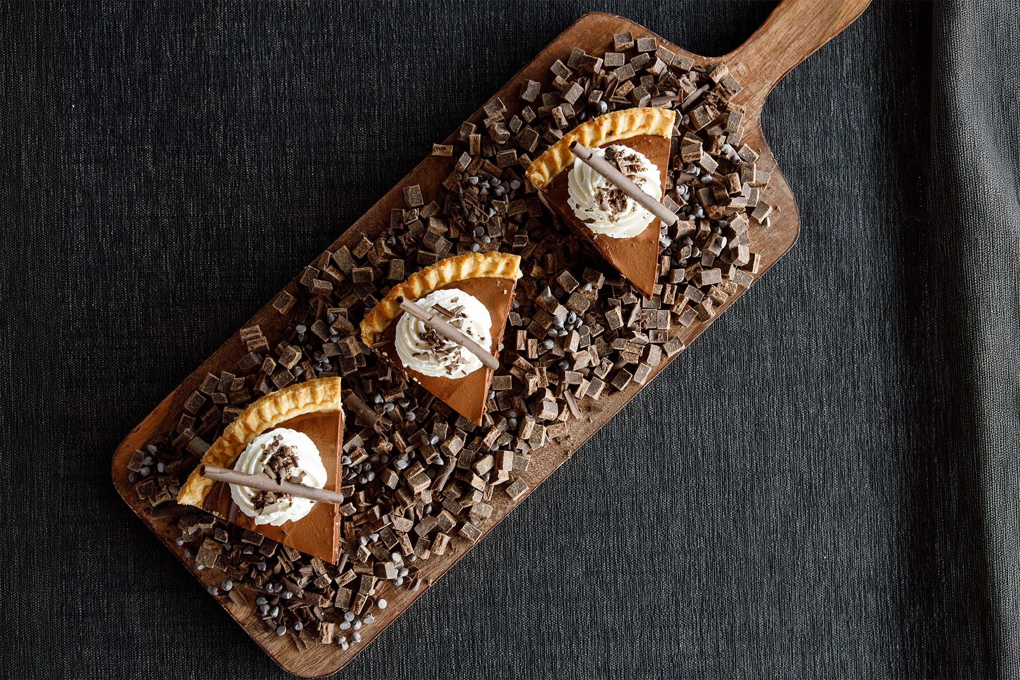 French silk pie slices served on a wood board.