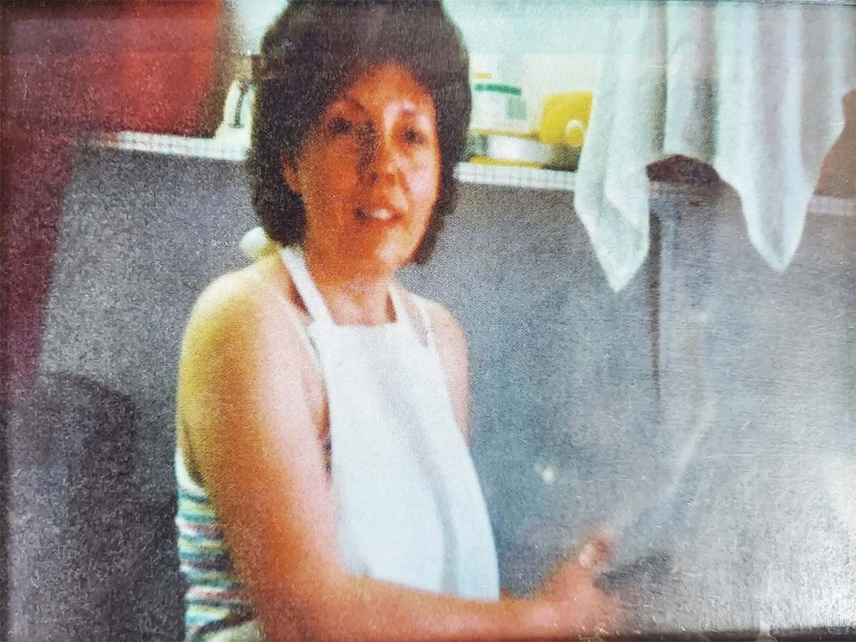 Woman wearing a white apron standing in a kitchen