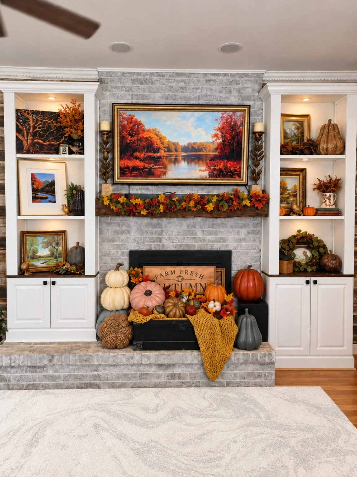Fall fireplace styled with pumpkins, autumn garland, framed landscape art, and seasonal shelf décor.