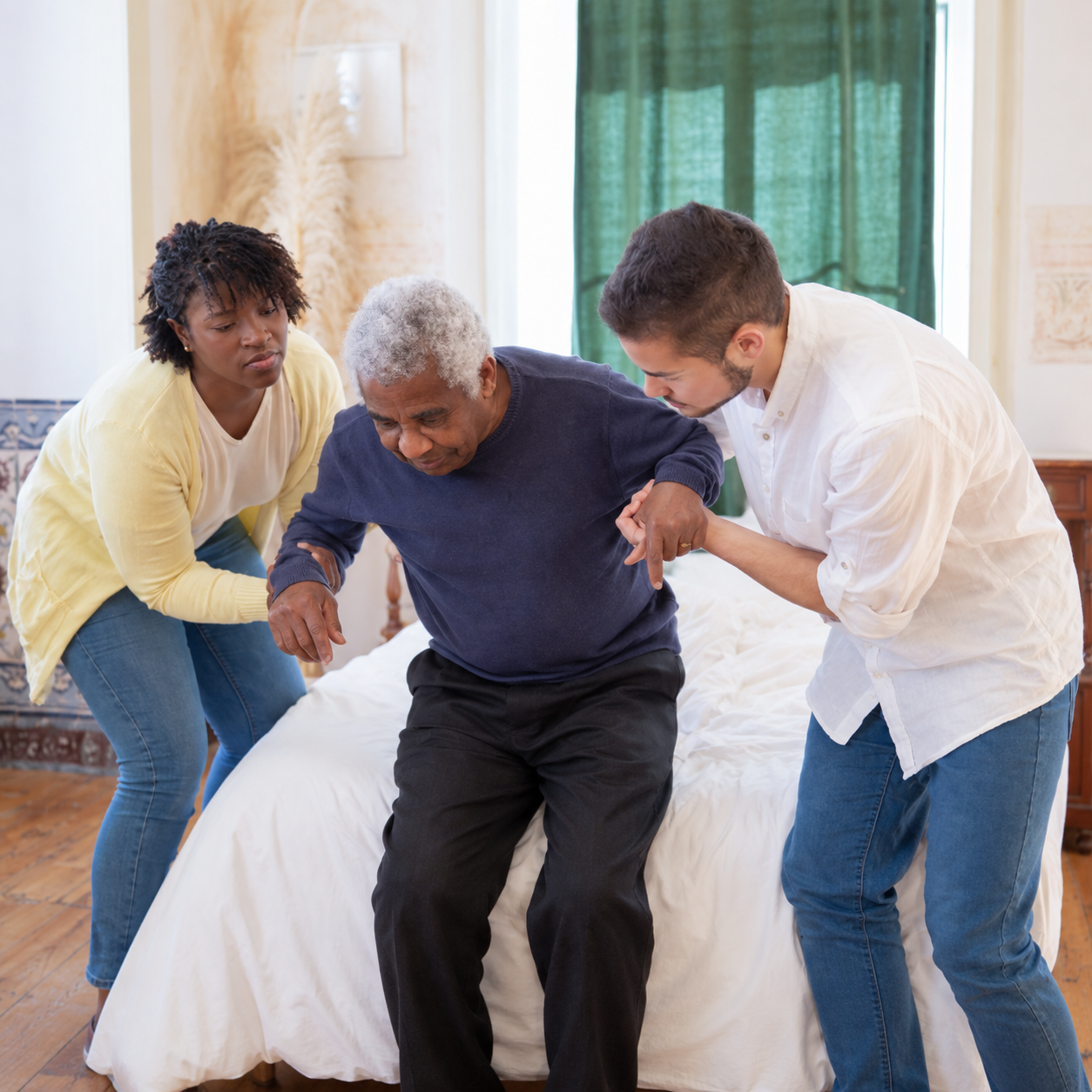 Healthcare professionals assisting a senior resident out of bed to demonstrate safe patient handling and mobility solutions.