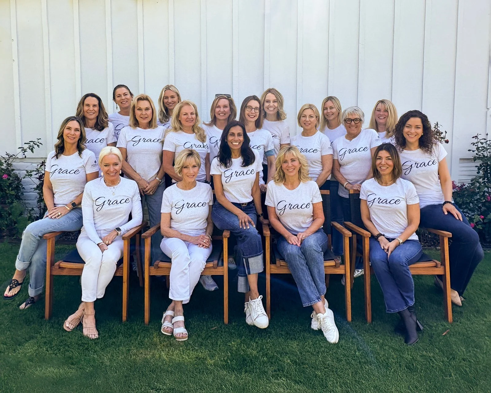 Mother's Grace board members and volunteers, wearing shirts that say Grace, gathered together outdoors