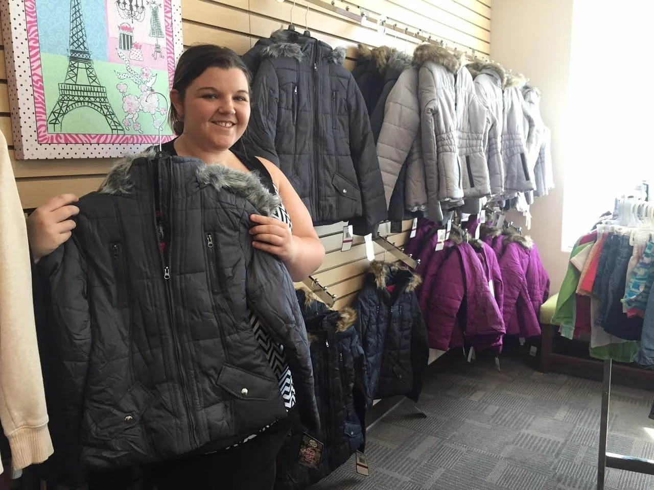 A retail partner helping sort winter coats for a Mother's Grace clothing drive
