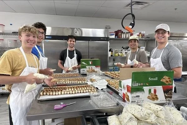 Volunteers preparing food in a kitchen for Mother's Grace