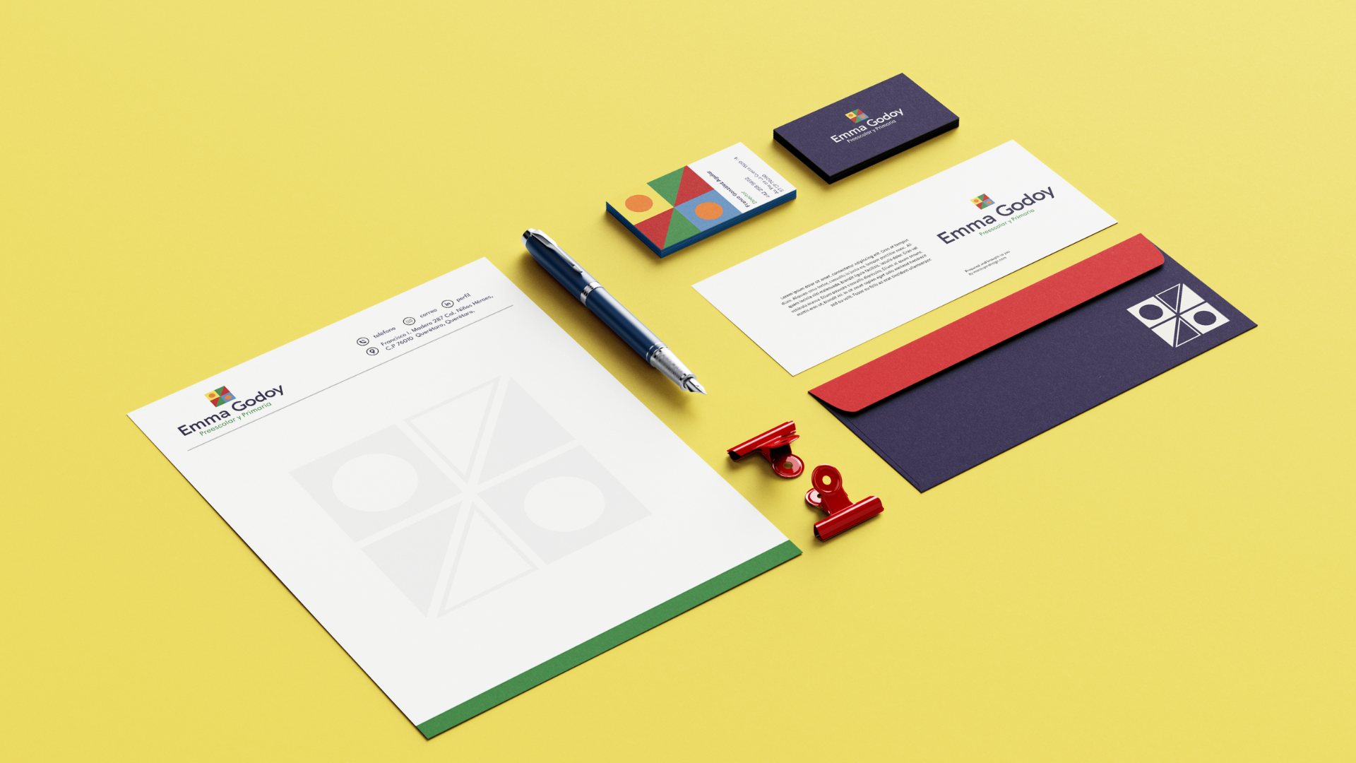 Papelería con cartas, bolígrafo, sujetapapeles, y papel membretado con nombre "Emma Goday" en colores vibrantes sobre fondo amarillo.