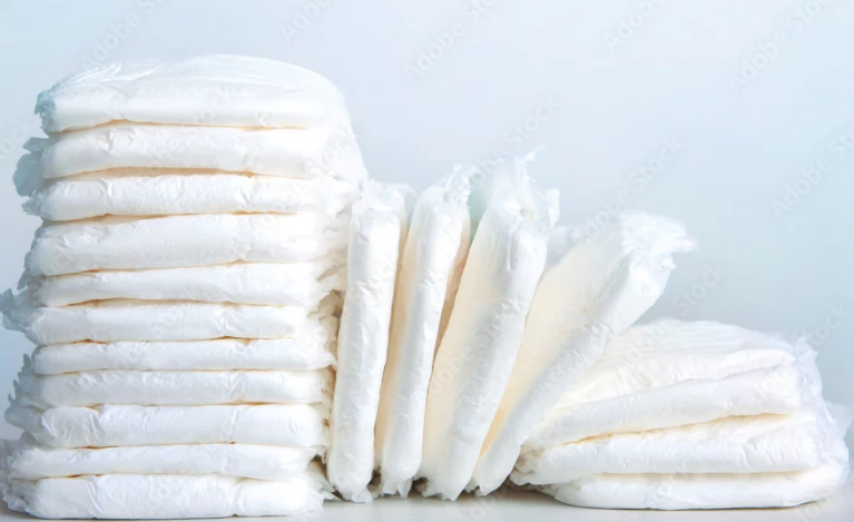 Stack of white disposable diapers.