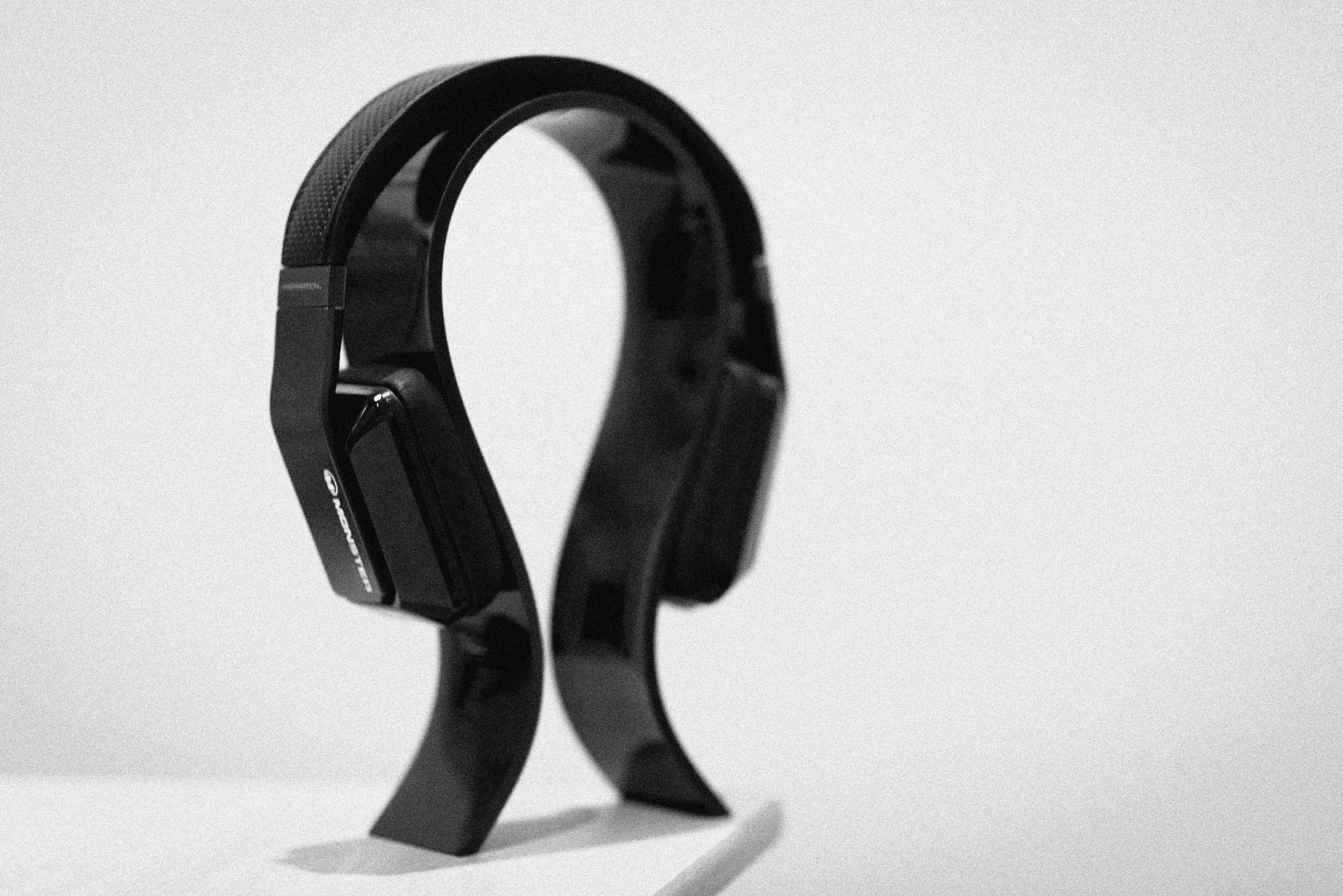 Black over-ear headphones on a white surface with a minimalist design.