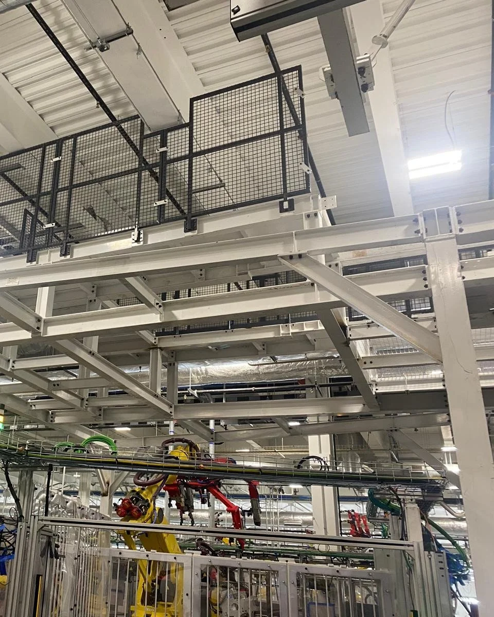 Industrial manufacturing bar and robotic arms on an assembly line.