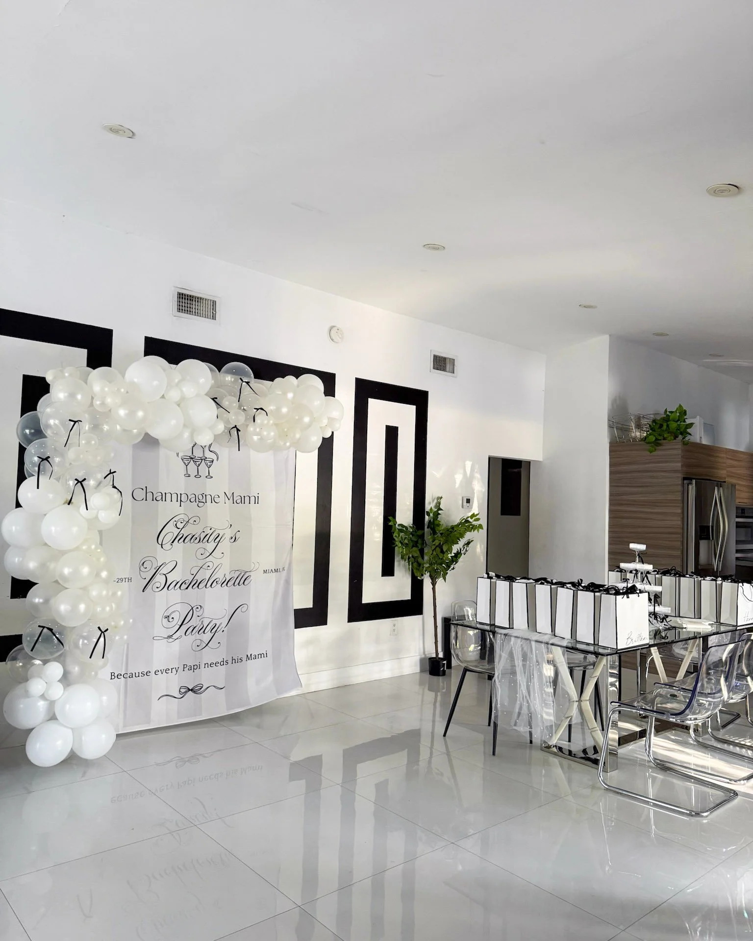 White balloon installation and curated gift display for a modern bachelorette celebration.