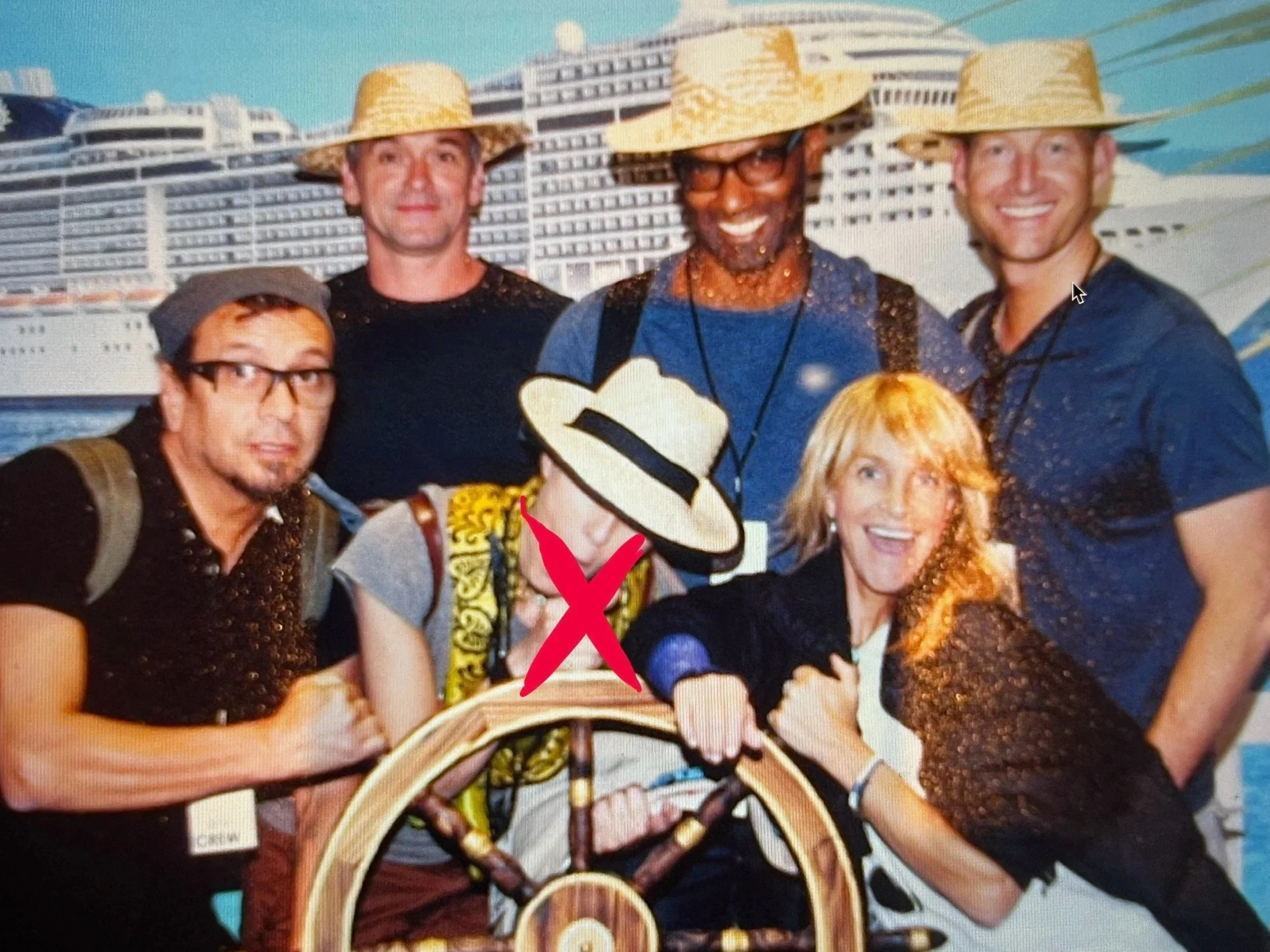 Group of five people on a cruise ship, wearing straw hats and smiling, with the ship's multiple decks in the background.
