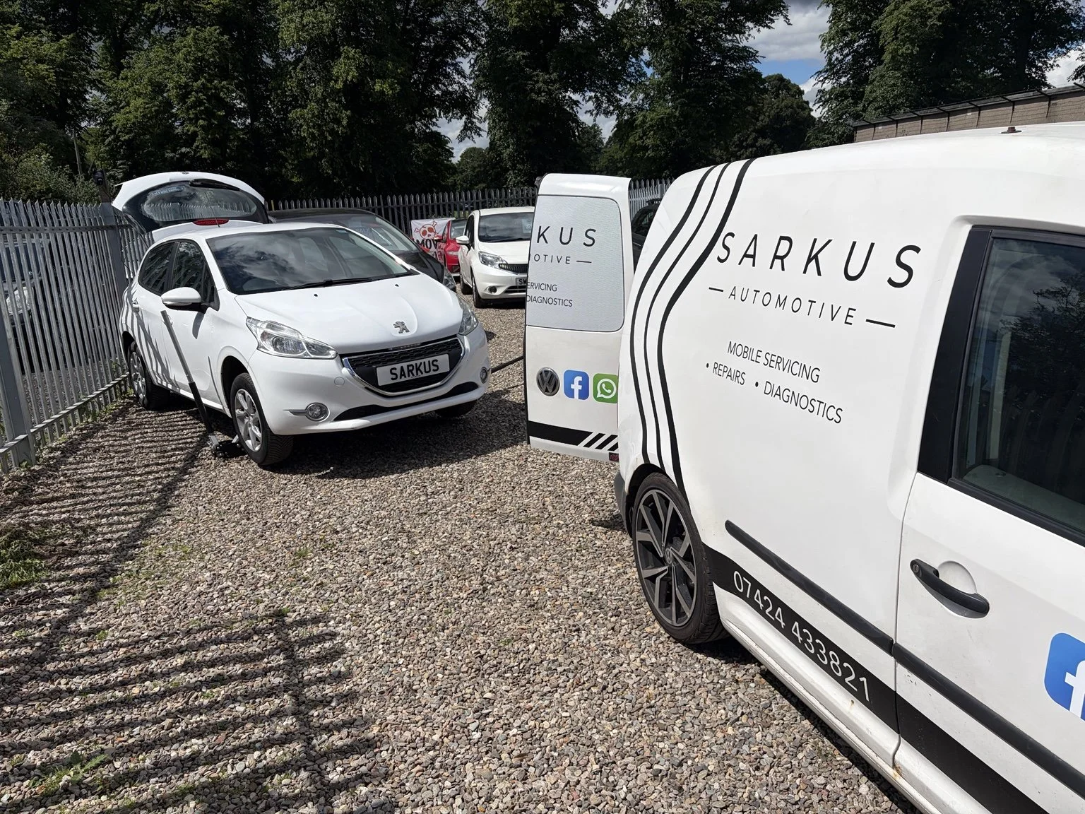 A parking lot with several white cars, including a parked Peugeot with a