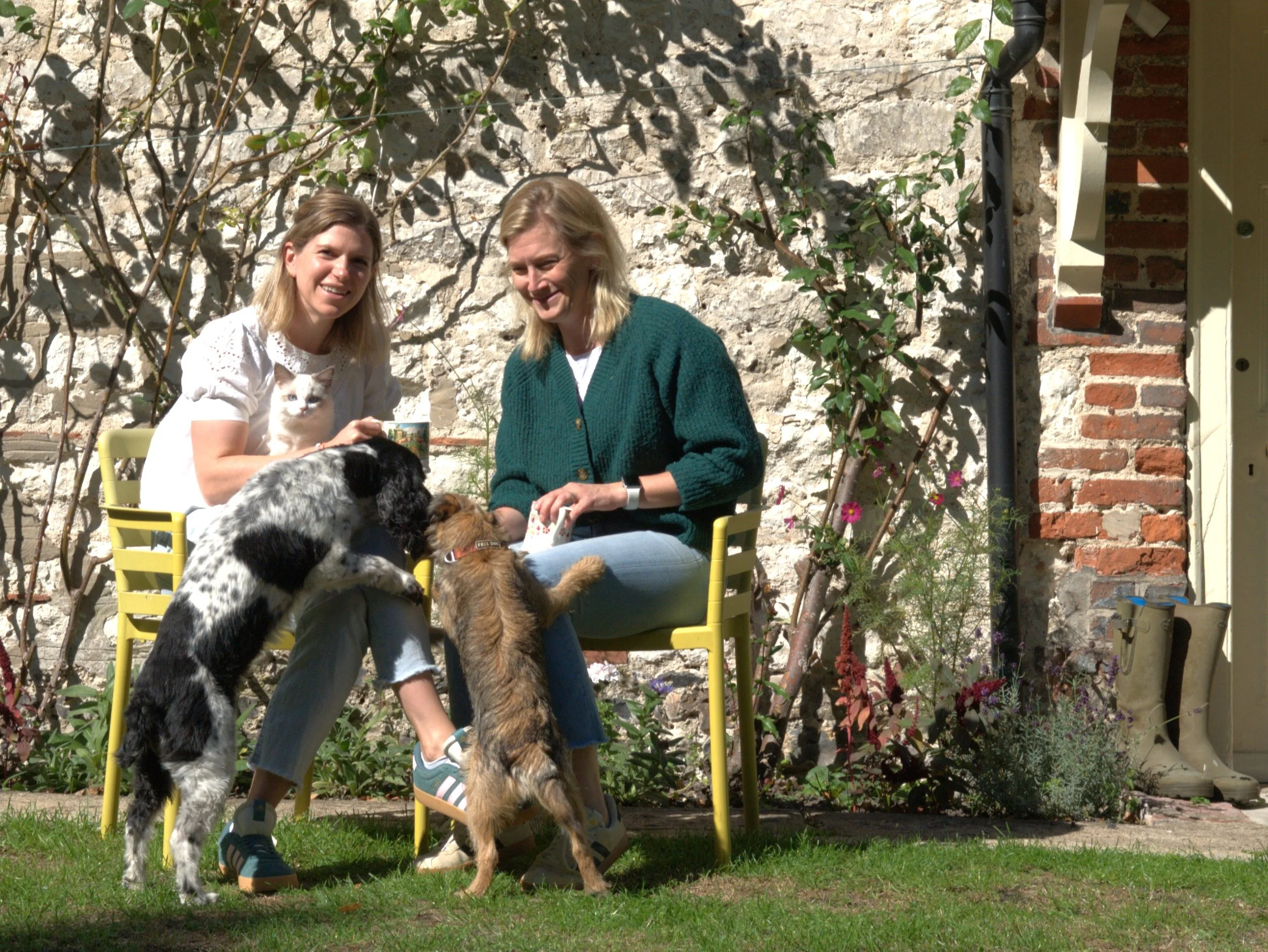 Hilary and Lizzie with their dogs chatting over coffee about their plans for Ottie & George Vets
