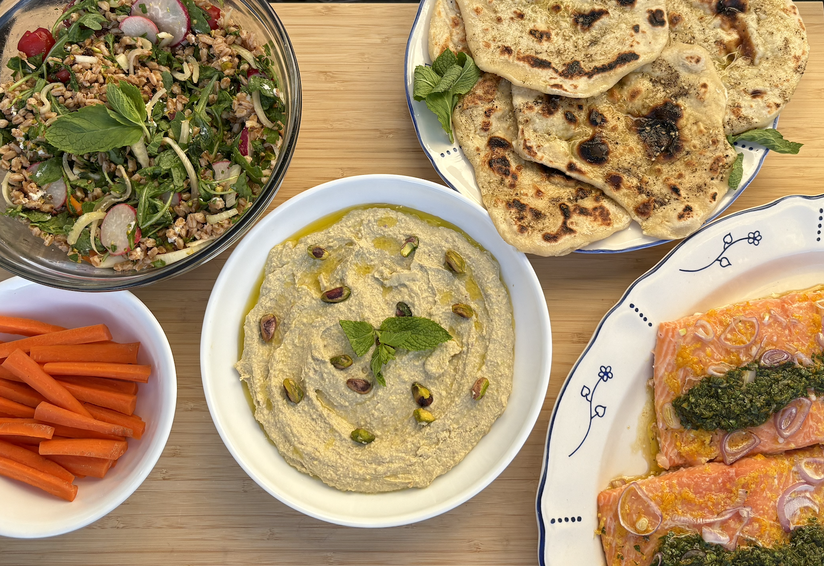 Slow roasted salmon with citrus salsa verde, farro salad, za'atar sourdough flatbread, & pistachio white bean hummus