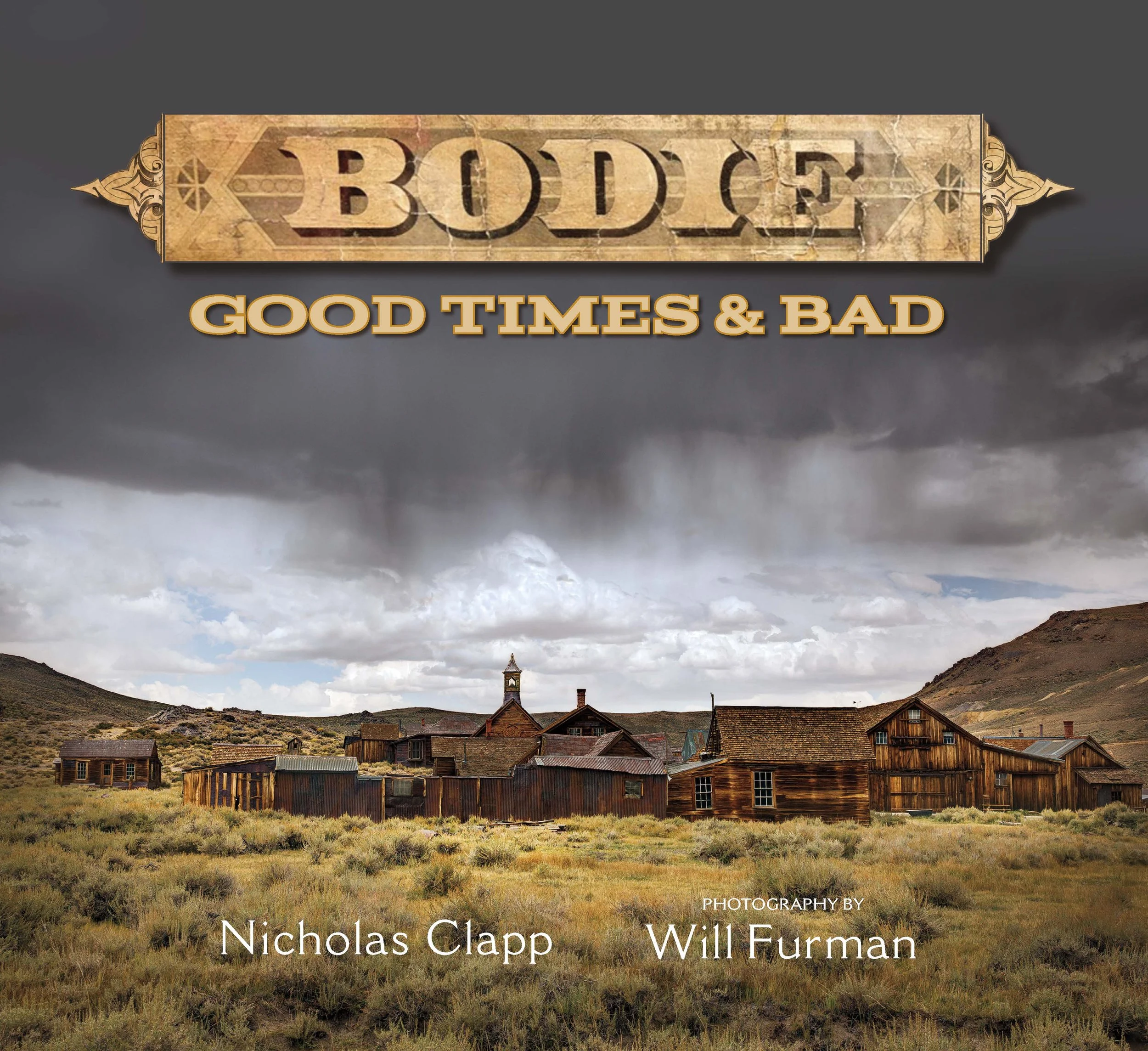 A landscape with a small old town and a church steeple, surrounded by hills and cloudy sky, with text overlay reading 'Booky: Good Times & Bad' and credits to photographer Nicholas Clapp and Will Furrman.