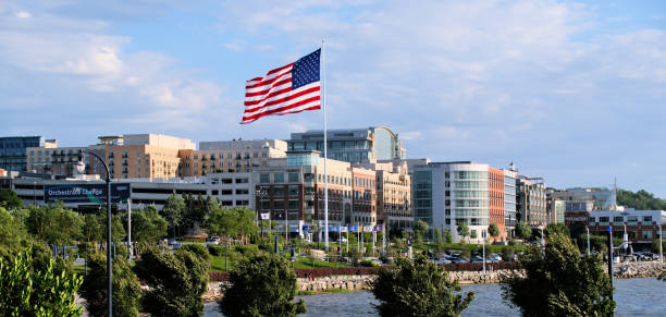 Modern parking garage and cityscape with a Ferris wheel in the background under a blue sky.