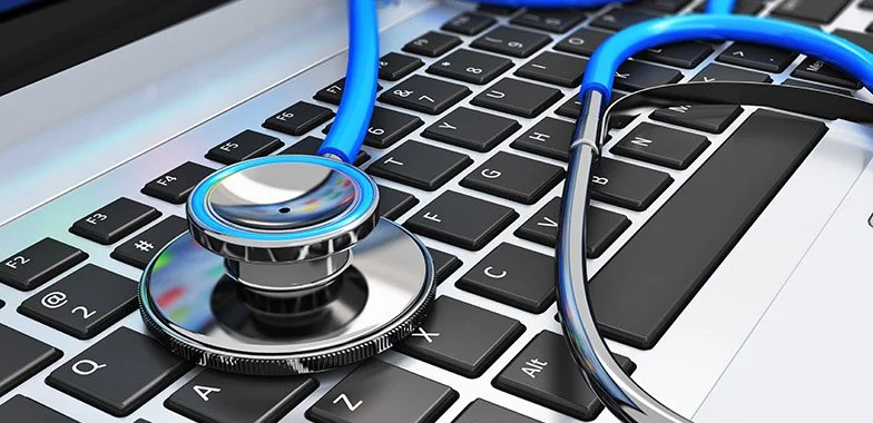 Stethoscope placed on a laptop keyboard.