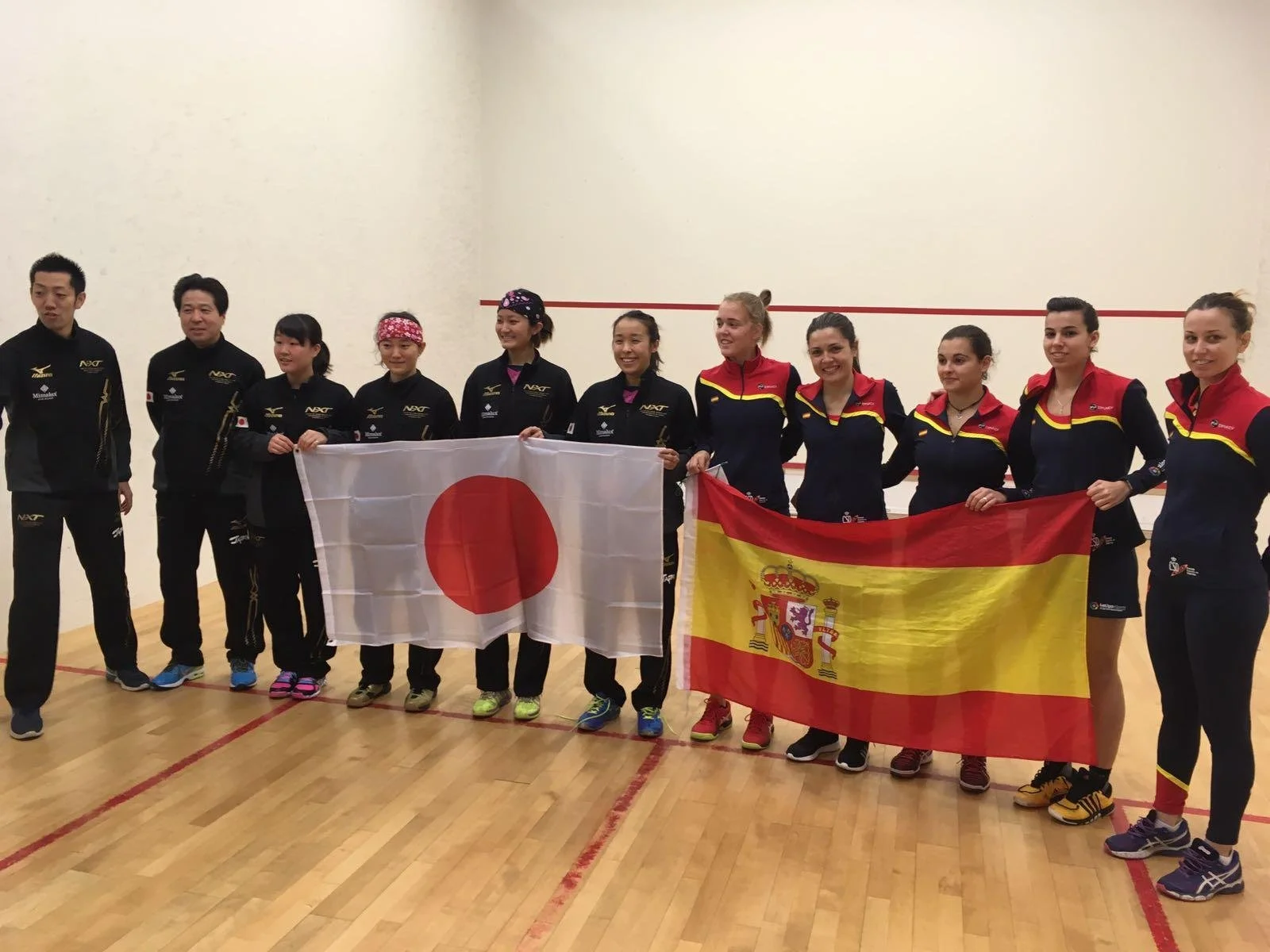 Photo of squash players holding Japan and Spain flags.