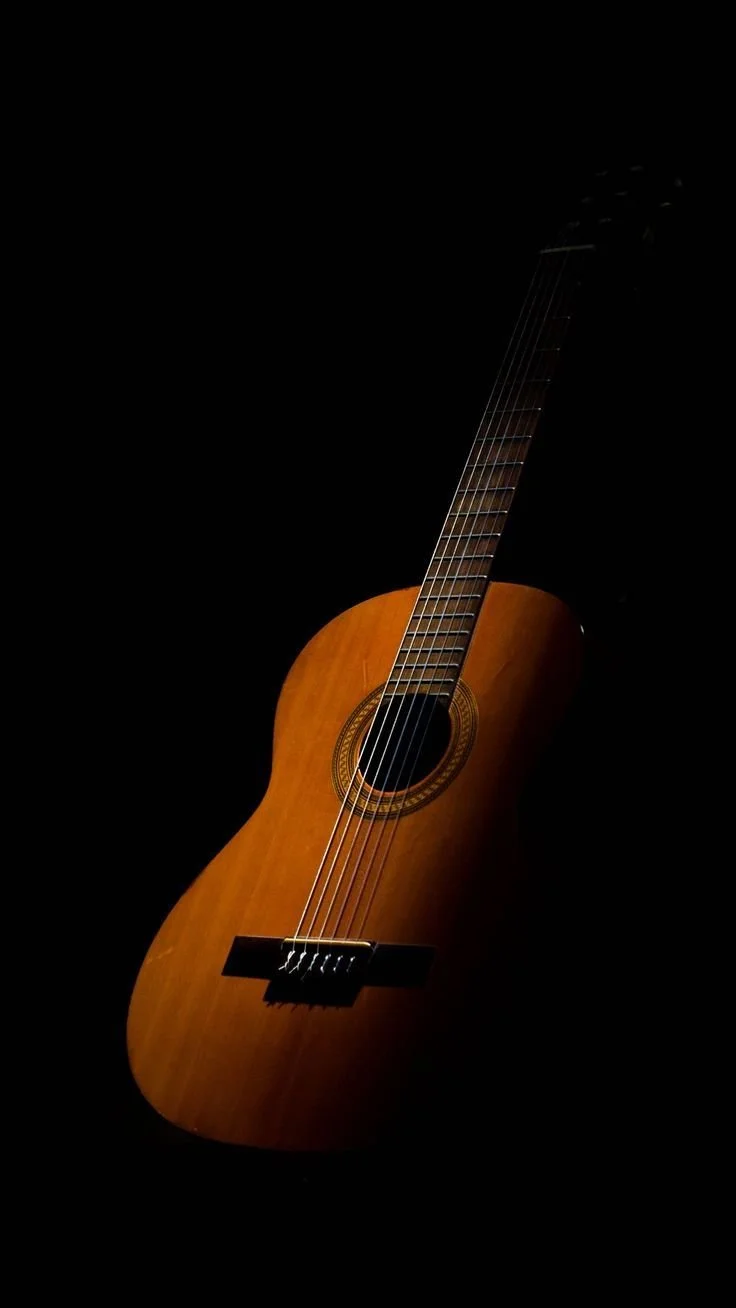 Classic wooden acoustic guitar against a black background