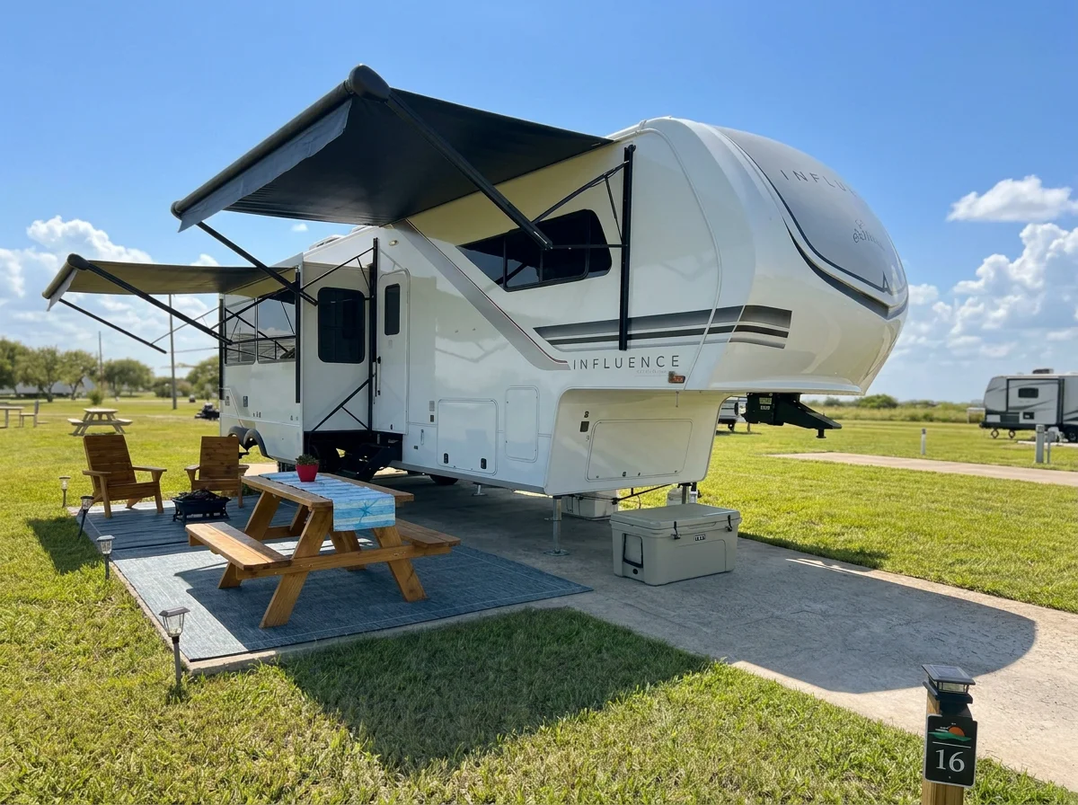 Level concrete RV pad with 50 amp full hookups and wide grass spacing for big rig fifth wheels in Rockport TX