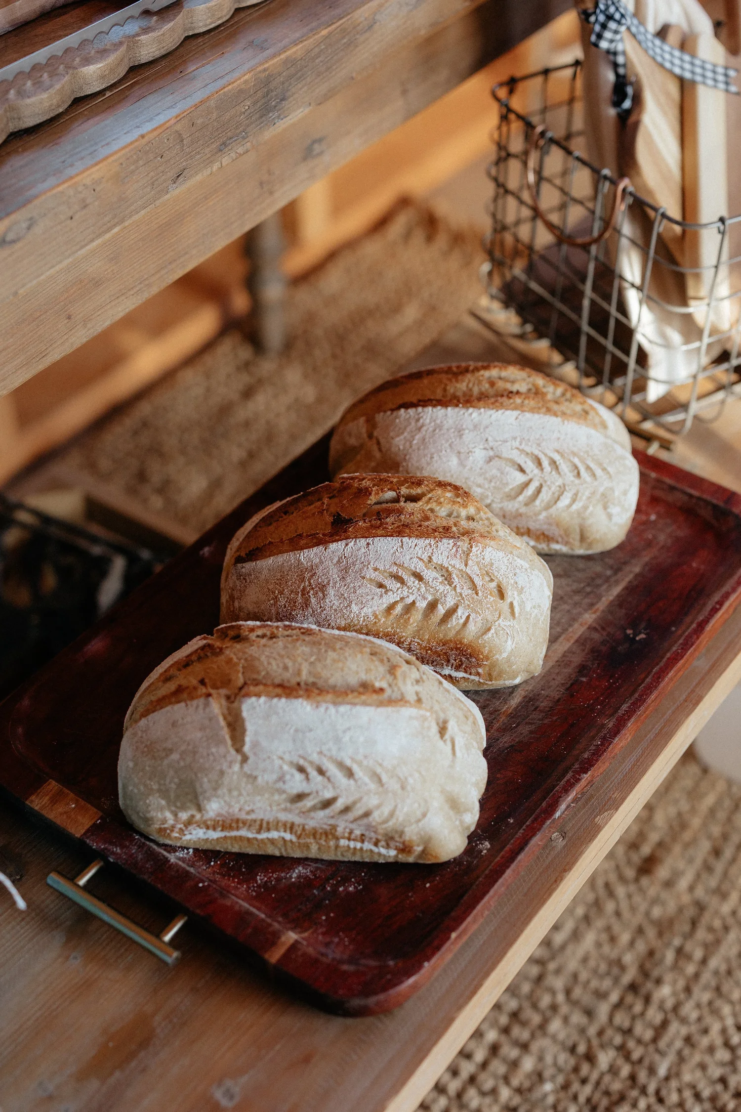 Fresh sourdough loaves on a wooden tray at the farm stand
