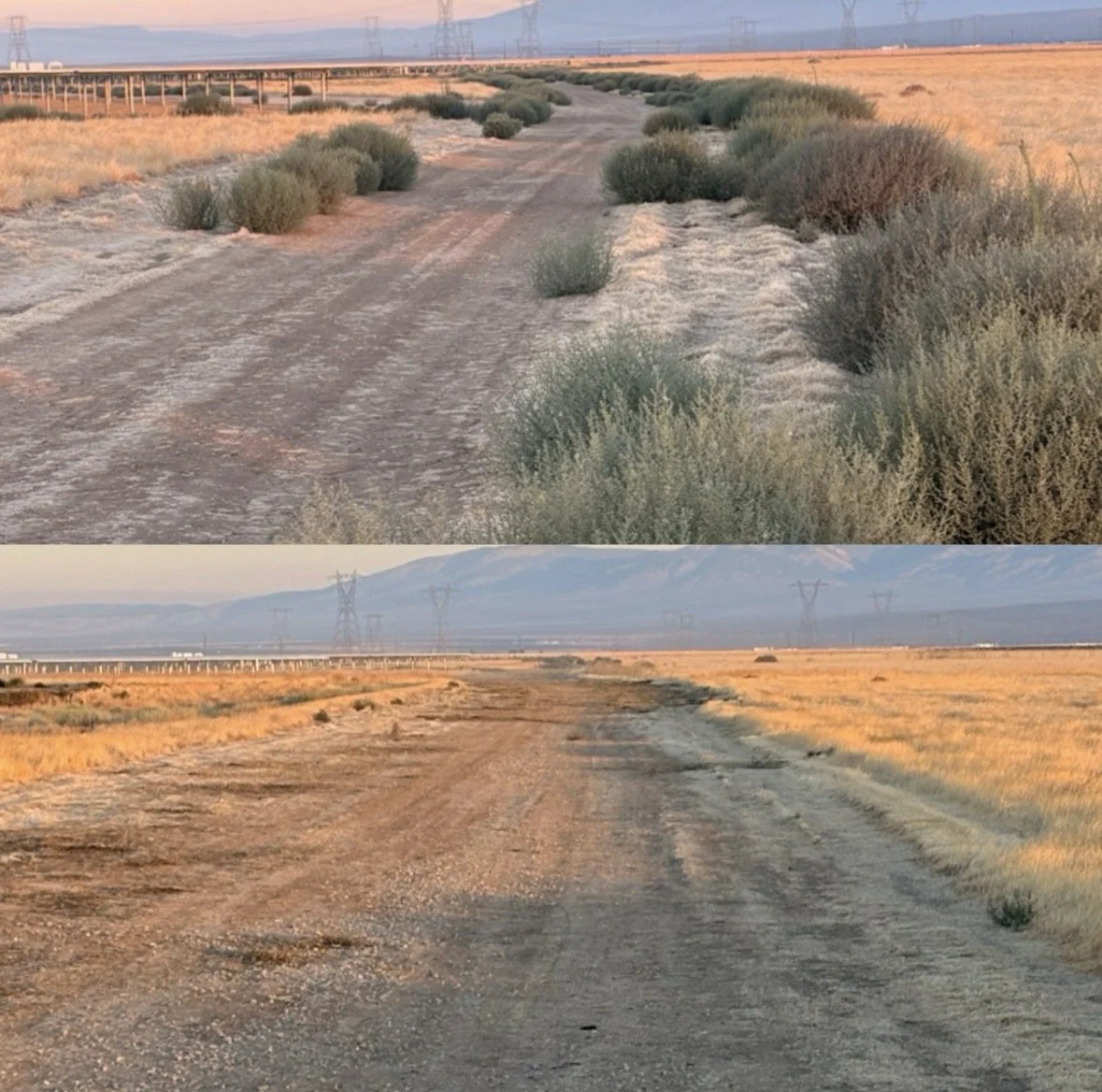 A dusty dirt road in a desert landscape with sparse vegetation, power lines, and mountains in the background during sunset.