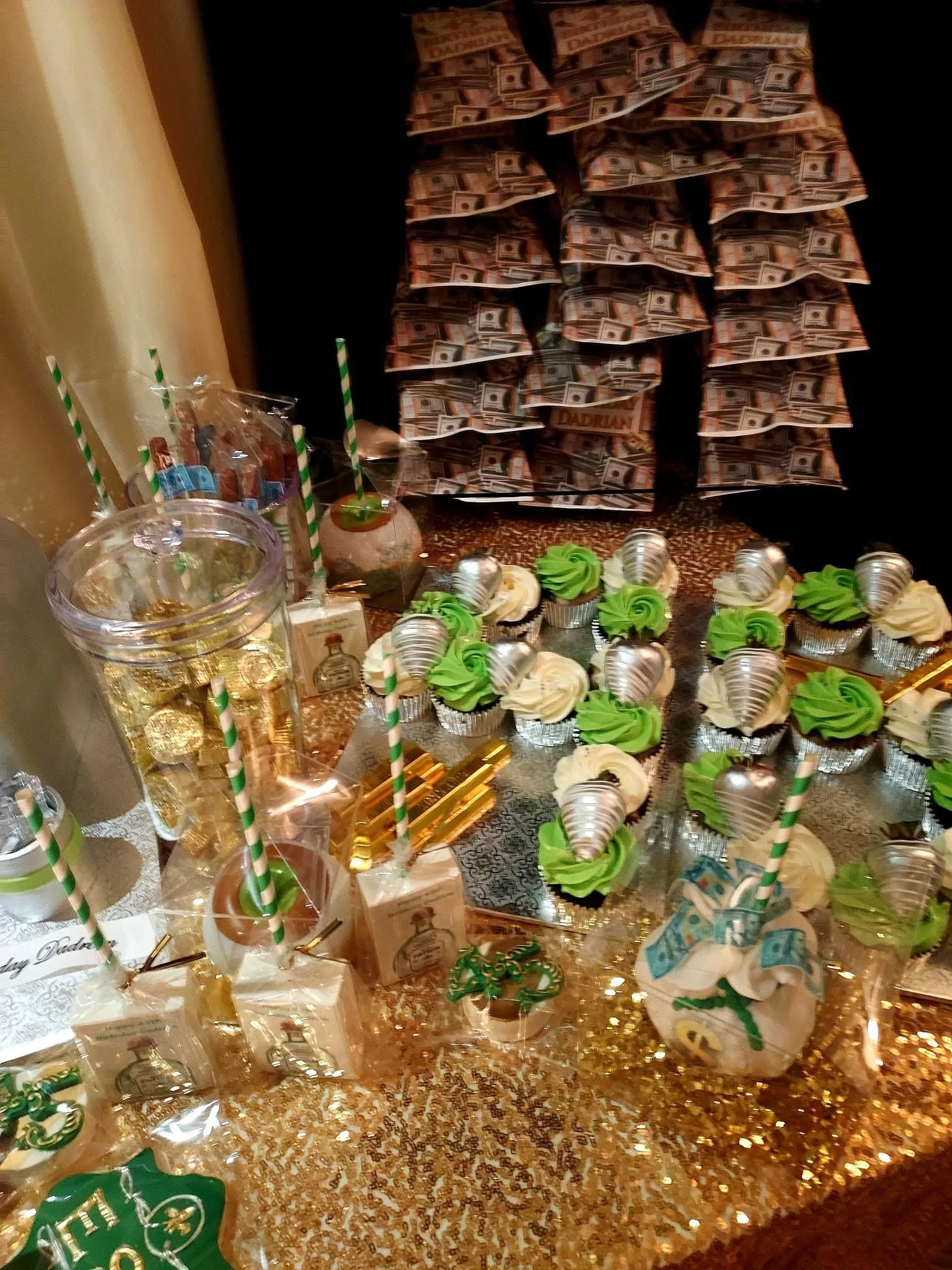 Get Rich or Die Tryin' dessert display with gold confetti, green-and-white cupcakes, striped straws, chocolate lollipops, and play money.