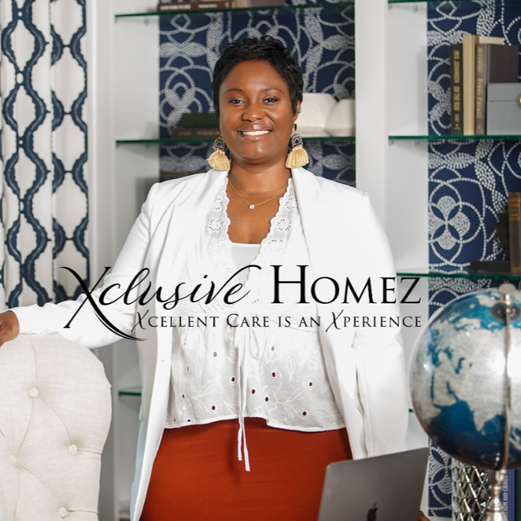 A woman with short black hair and earrings, smiling, standing in a home office with bookshelves and decorative items in the background. She is wearing a white blazer over a white top and a red skirt, with a laptop and a globe on the desk. The text overlay reads, "Exclusive Homez - Excellent care is an experience."