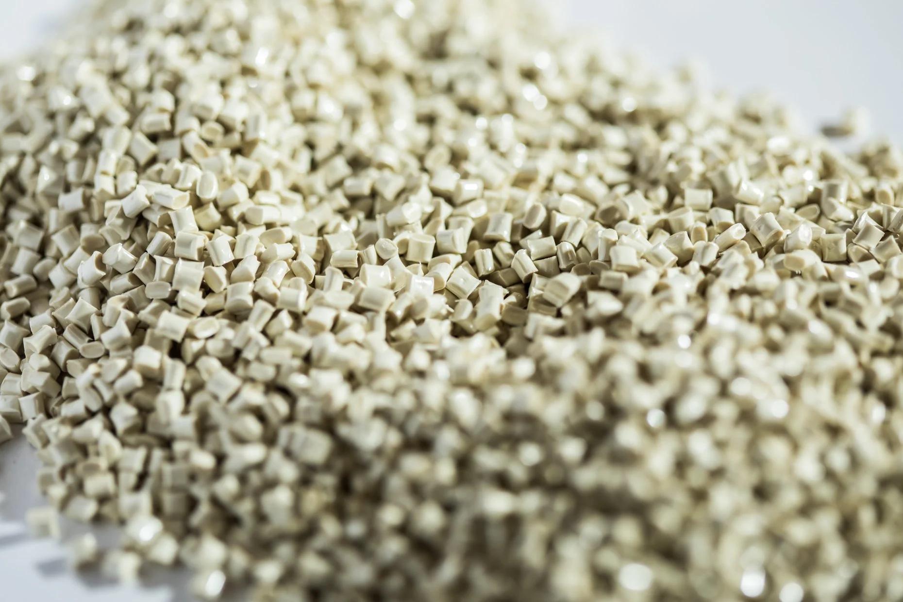 Close-up of a large pile of small, off-white ceramic or plastic pellets.
