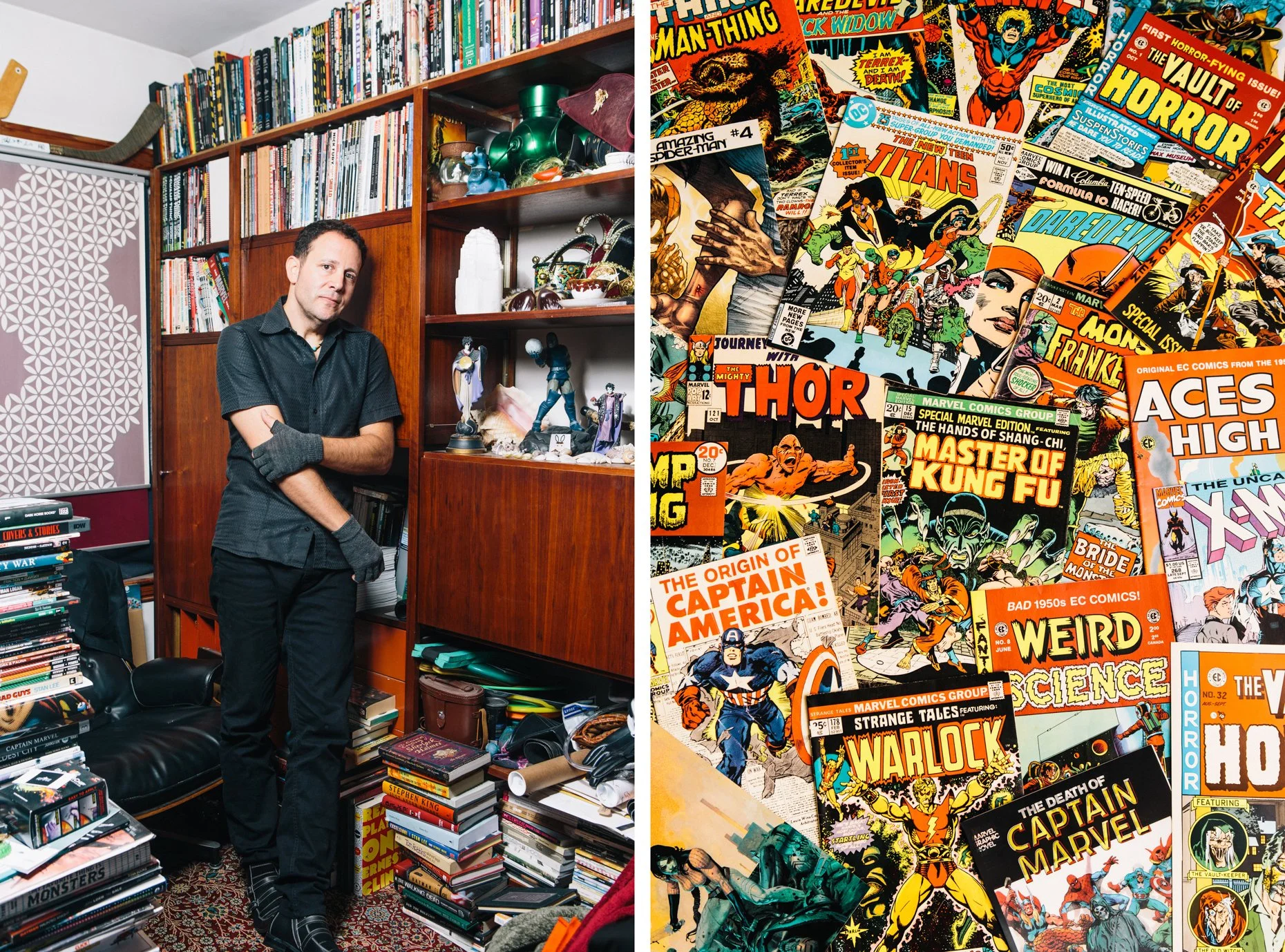 A man standing inside a room filled with a large collection of comic books, graphic novels, and collectibles. The room has wooden shelves and a stack of books on a table, with various superhero and sci-fi comic covers displayed on the right side.